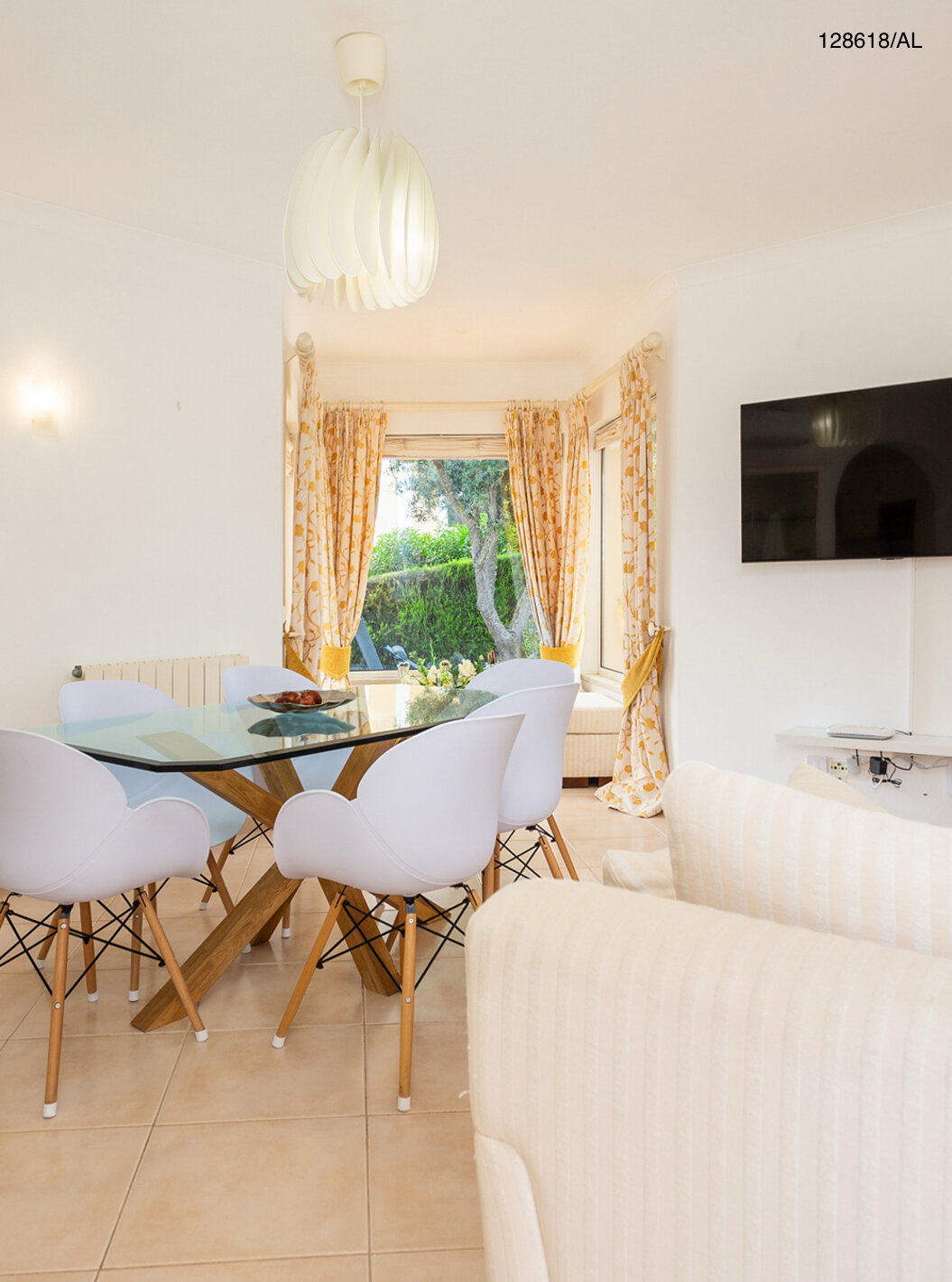 De villa Pestana Carvoeiro Golf V3 Superior heeft een woonkamer met een tafel van glas, stoelen en een televisie