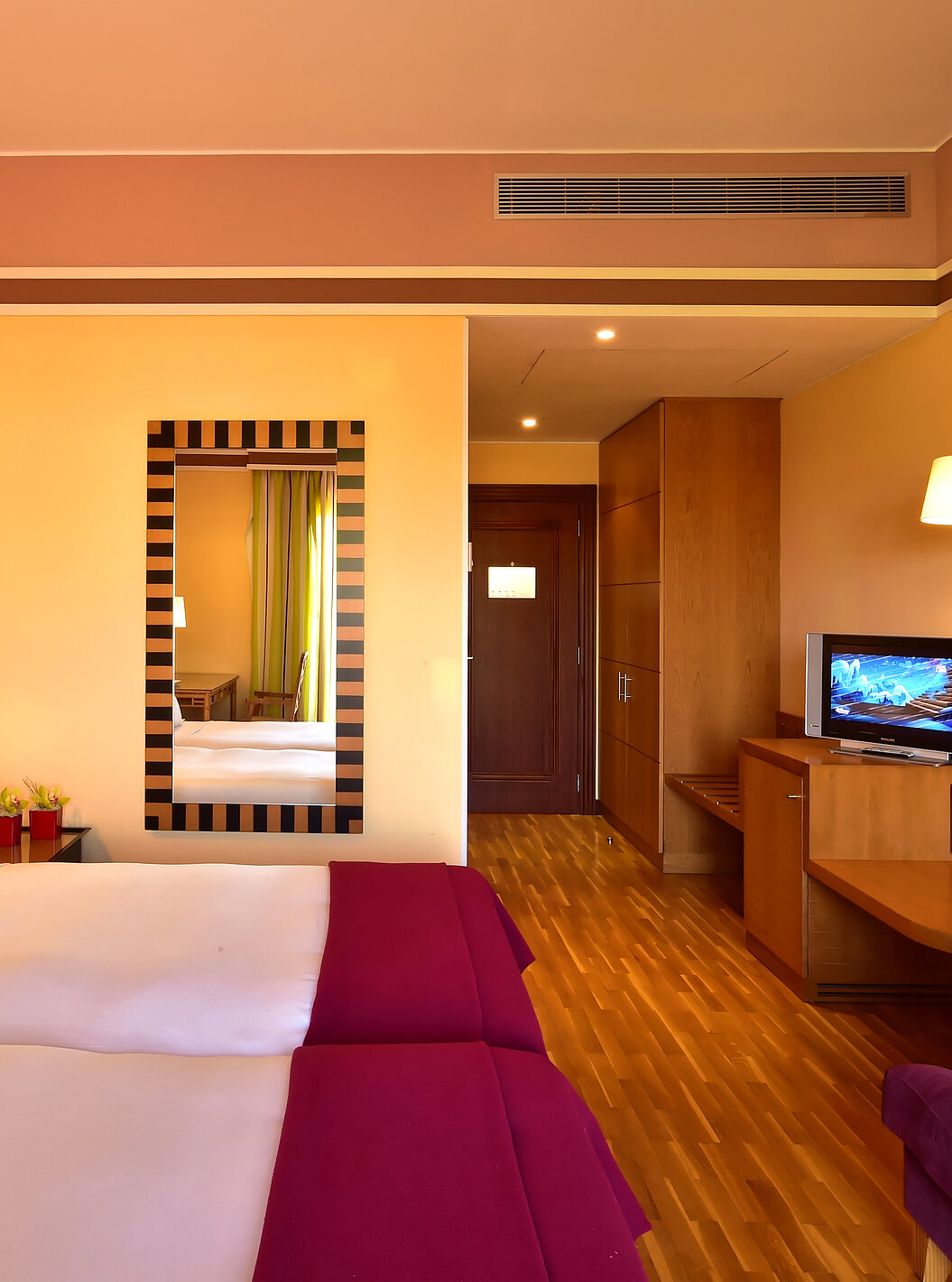 De Klassieke Tweepersoonskamer - Tuinzicht van Pestana Sintra Golf heeft twee bedden, een spiegel aan de muur, een tv en bank