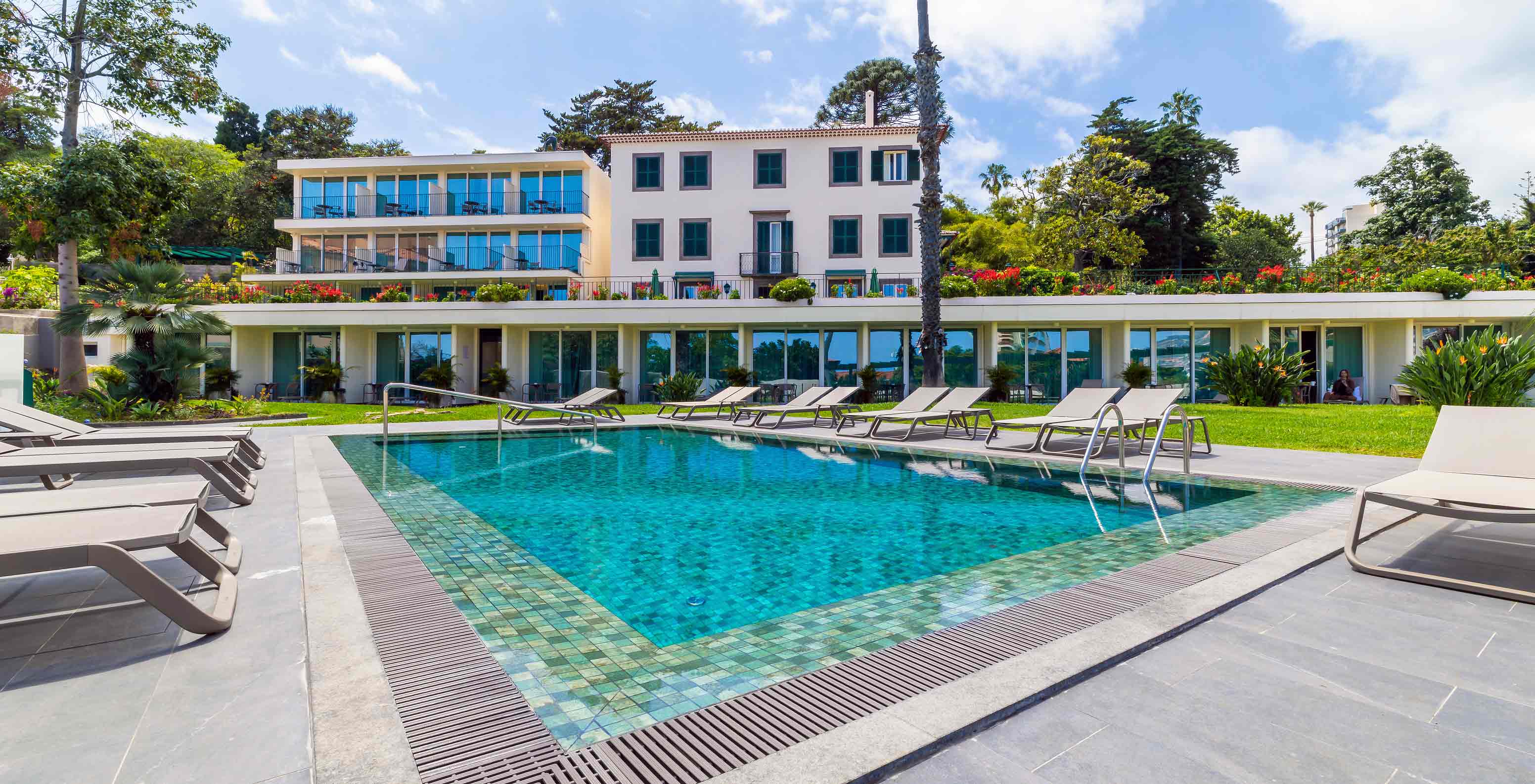 Uitzicht vanaf het terras van Pestana Quinta Perestrello op het zwembad en de heuvel van het eiland Madeira