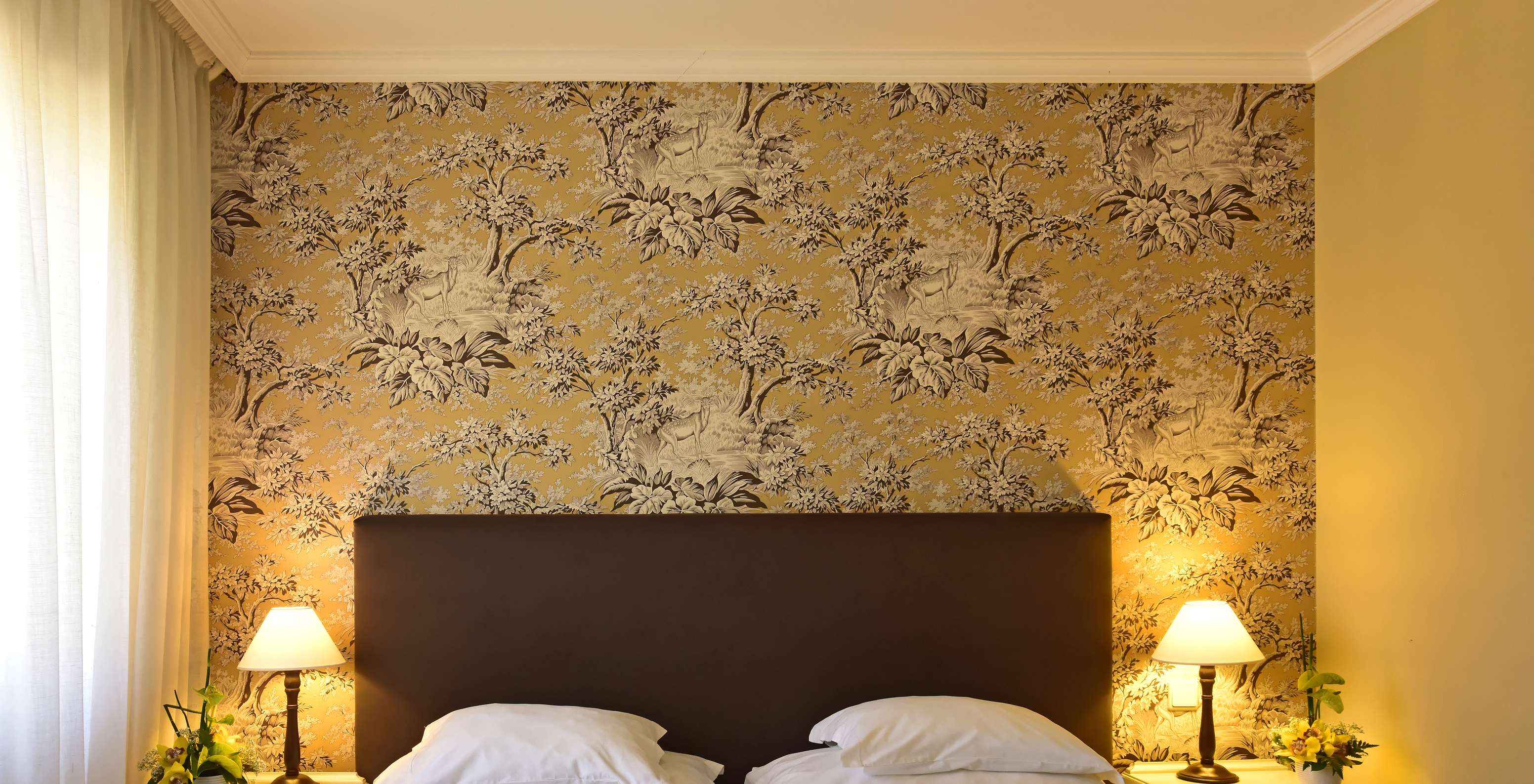 De Twin superior met Jacuzzi van Pestana Village heeft een tweepersoonsbed met hoofdeinde en kastanjebruin dekbed en behang