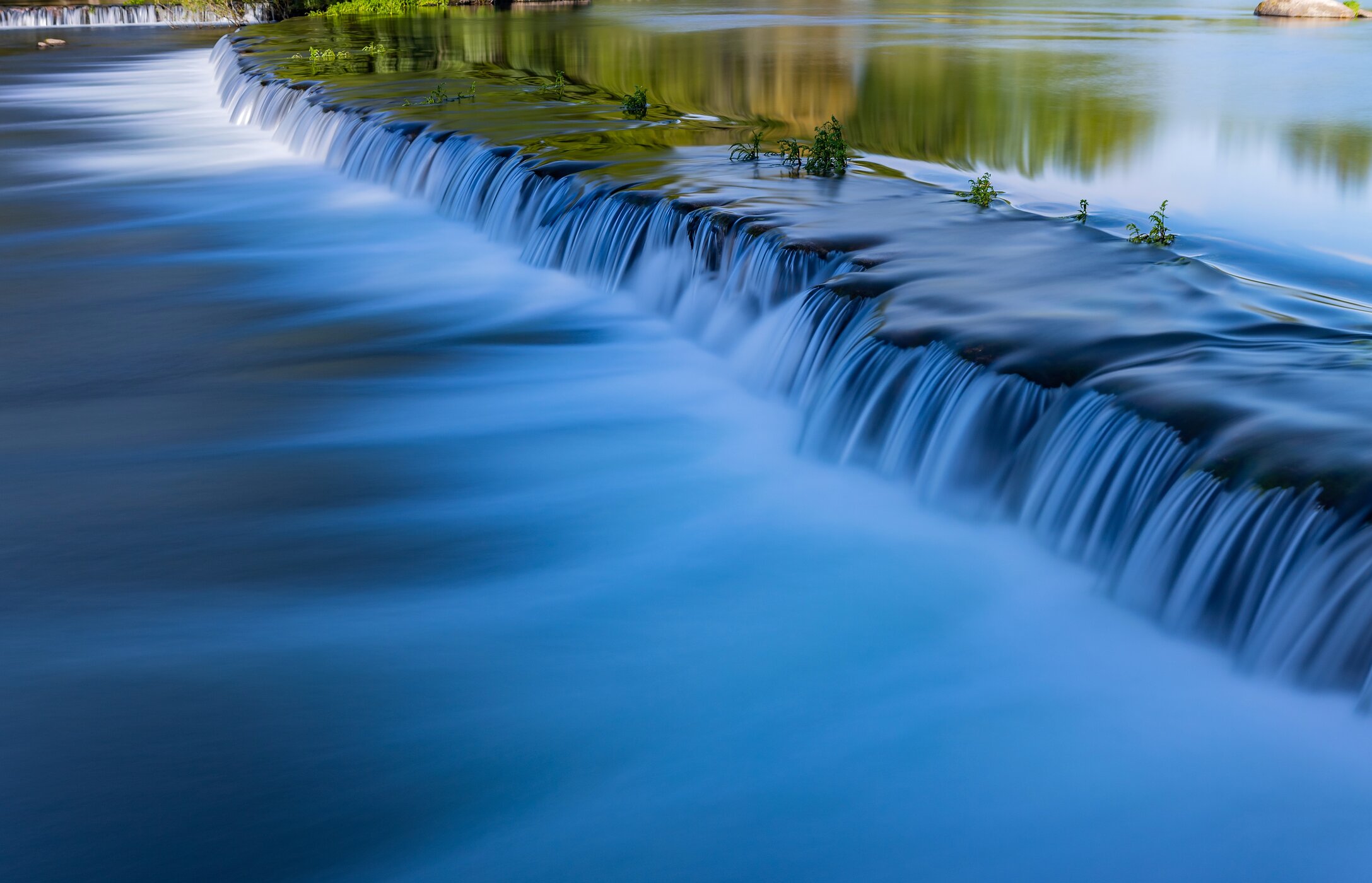 Panoramisch uitzicht op het strand van Adaufe, met kristalhelder water, omgeven door rotsen en vegetatie