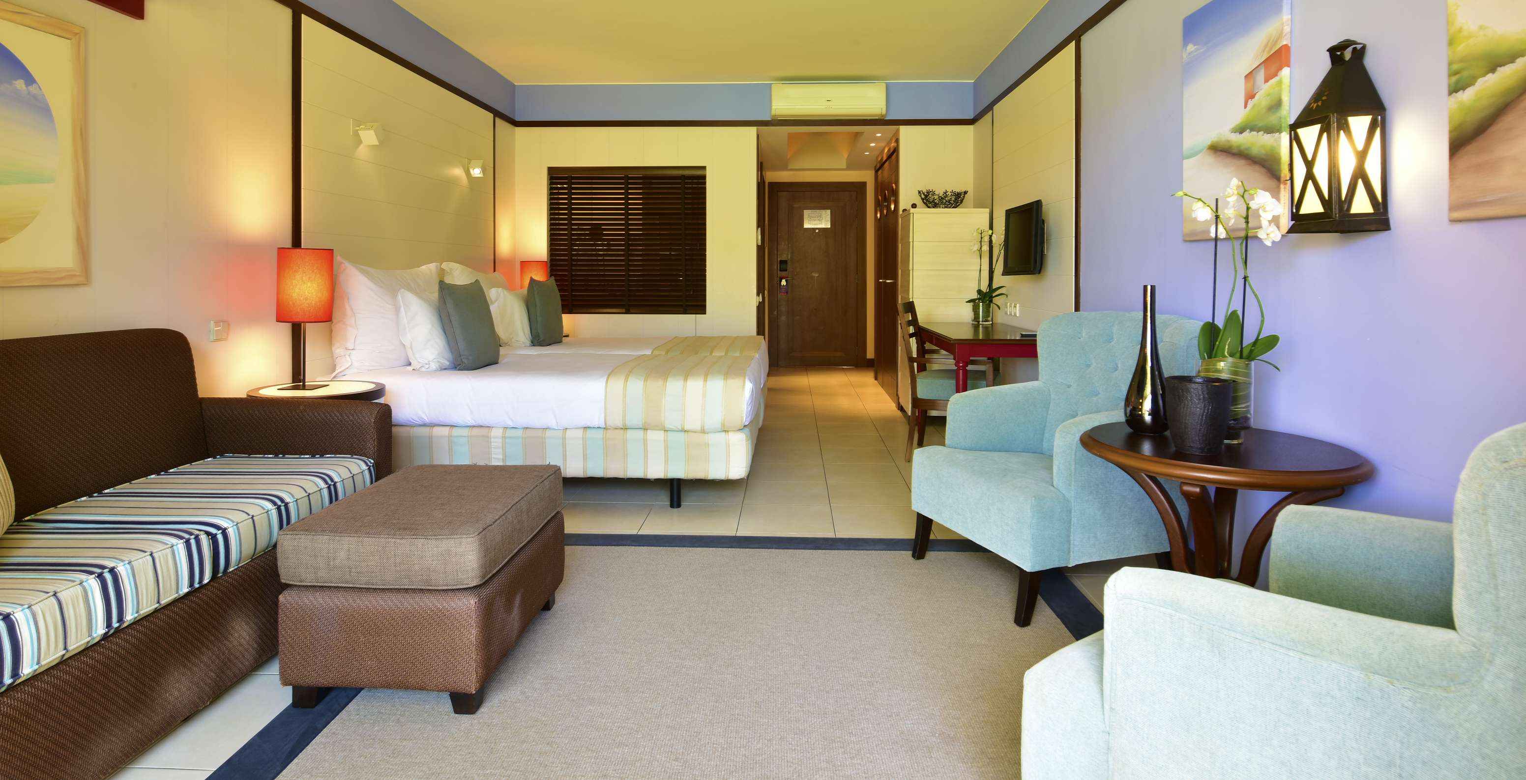 De Zwembadzicht Tweepersoonskamer van Pestana Porto Santo All Inclusive heeft een bank twee fauteuils en een televisie