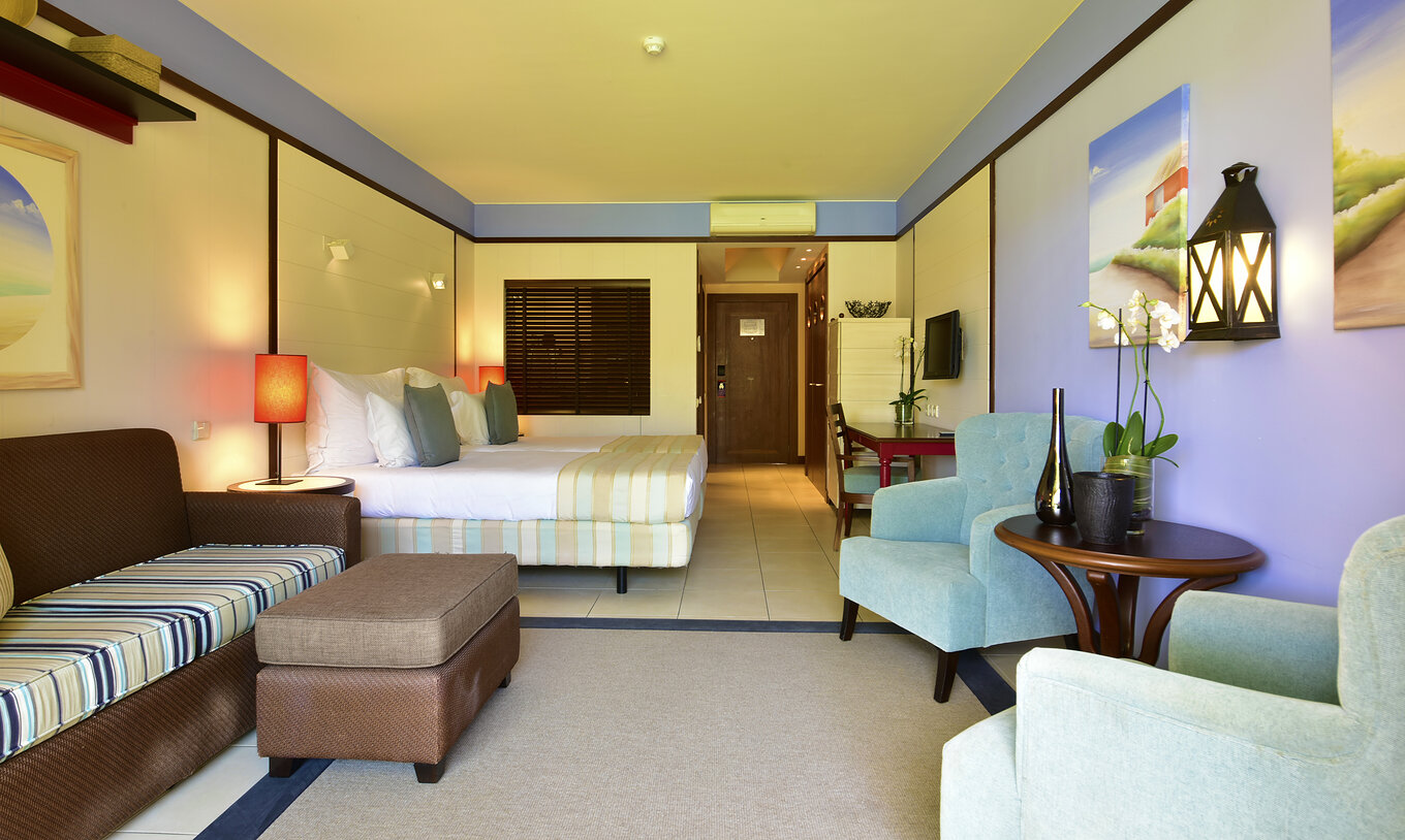 De Zwembadzicht Tweepersoonskamer van Pestana Porto Santo All Inclusive heeft een bank twee fauteuils en een televisie