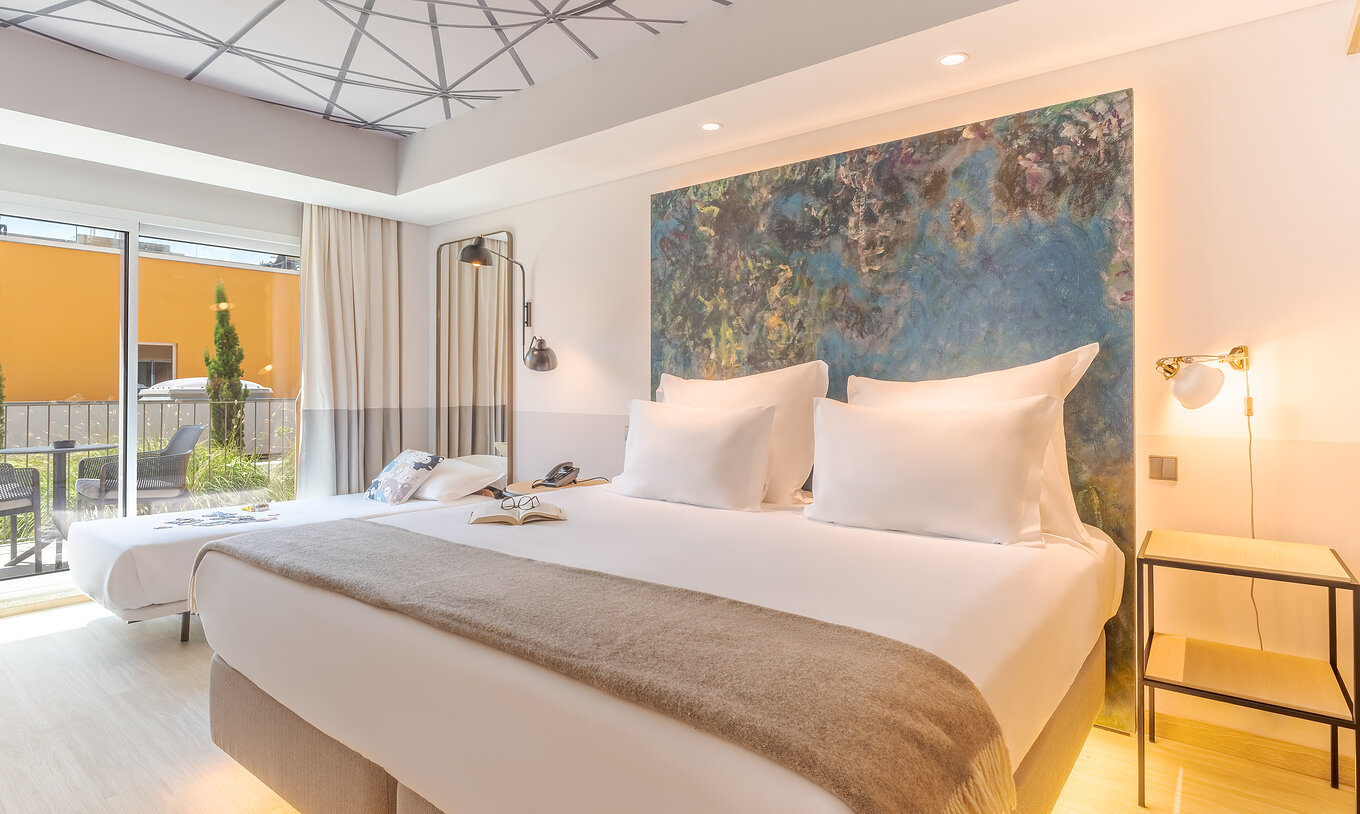 De Superior kamer van Pestana Douro Riverside heeft een tweepersoonsbed en een eenpersoonsbed, nachtkastje en balkon