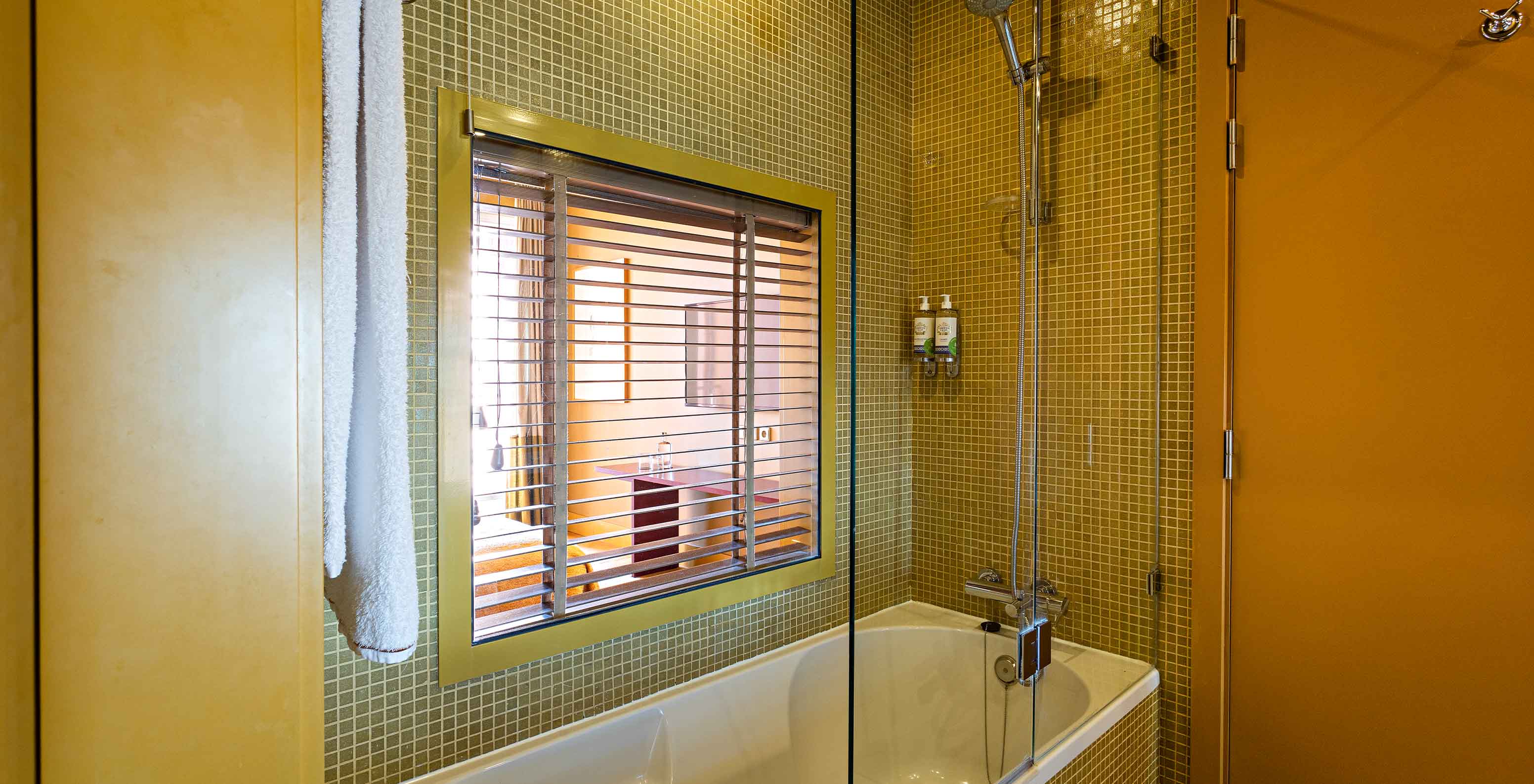 De Suite Balcony heeft een badkamer met bad en raam naar de slaapkamer