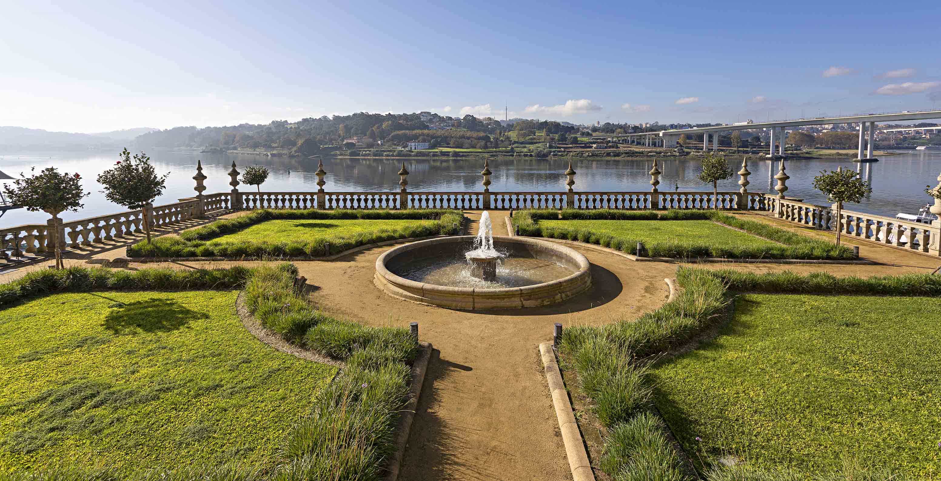 Uitzicht op de tuinen van Pestana Palácio do Freixo, met een fontein in het midden en de rivier de Douro erachter