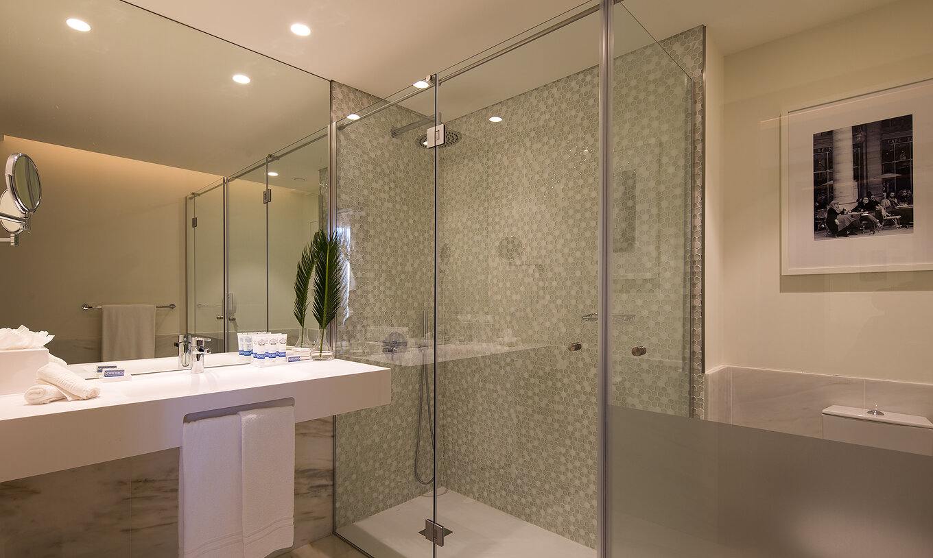 De Master Suite van Pestana Porto - A Brasileira heeft een badkamer met douchecabine en een grote wastafel