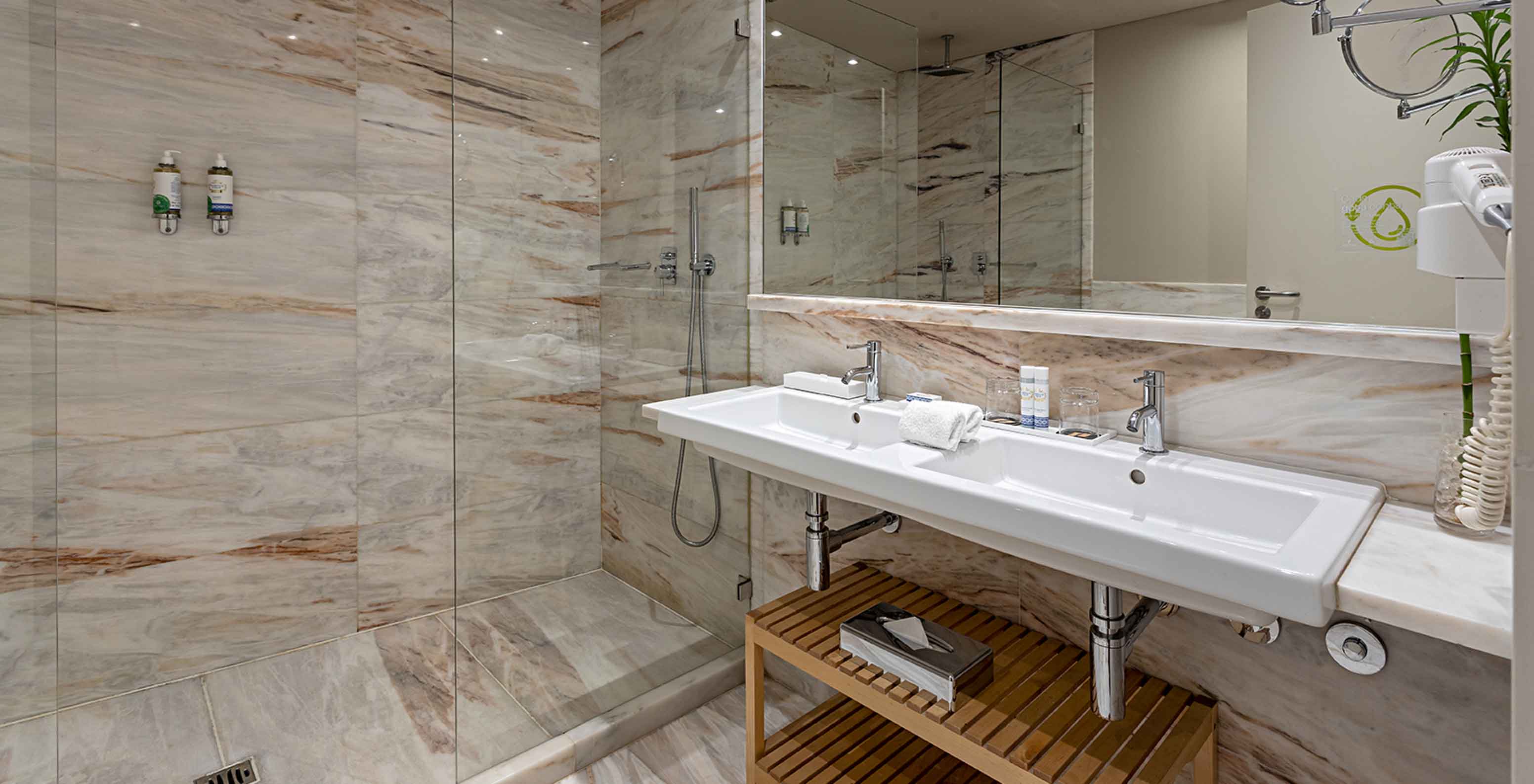 De Heritage Suite van het Pestana Vintage Porto heeft een badkamer met marmeren muren, een wastafel en een douche