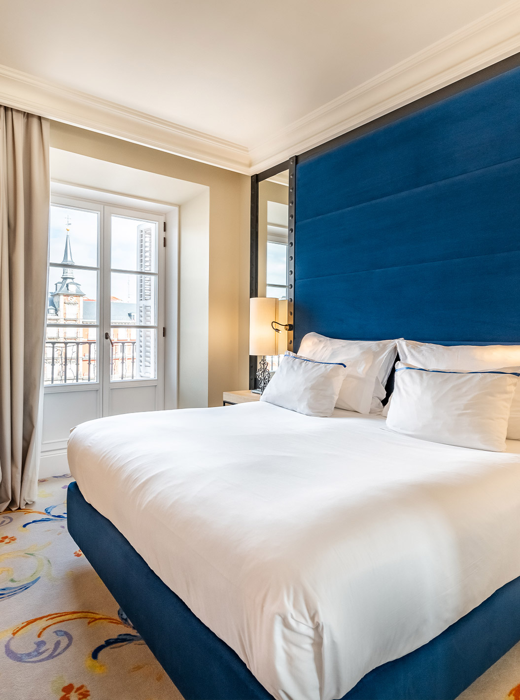 De Deluxe Plaza Mayor van Pestana Plaza Mayor Madrid heeft een tweepersoonsbed, twee nachttafels en een spiegel op de muur