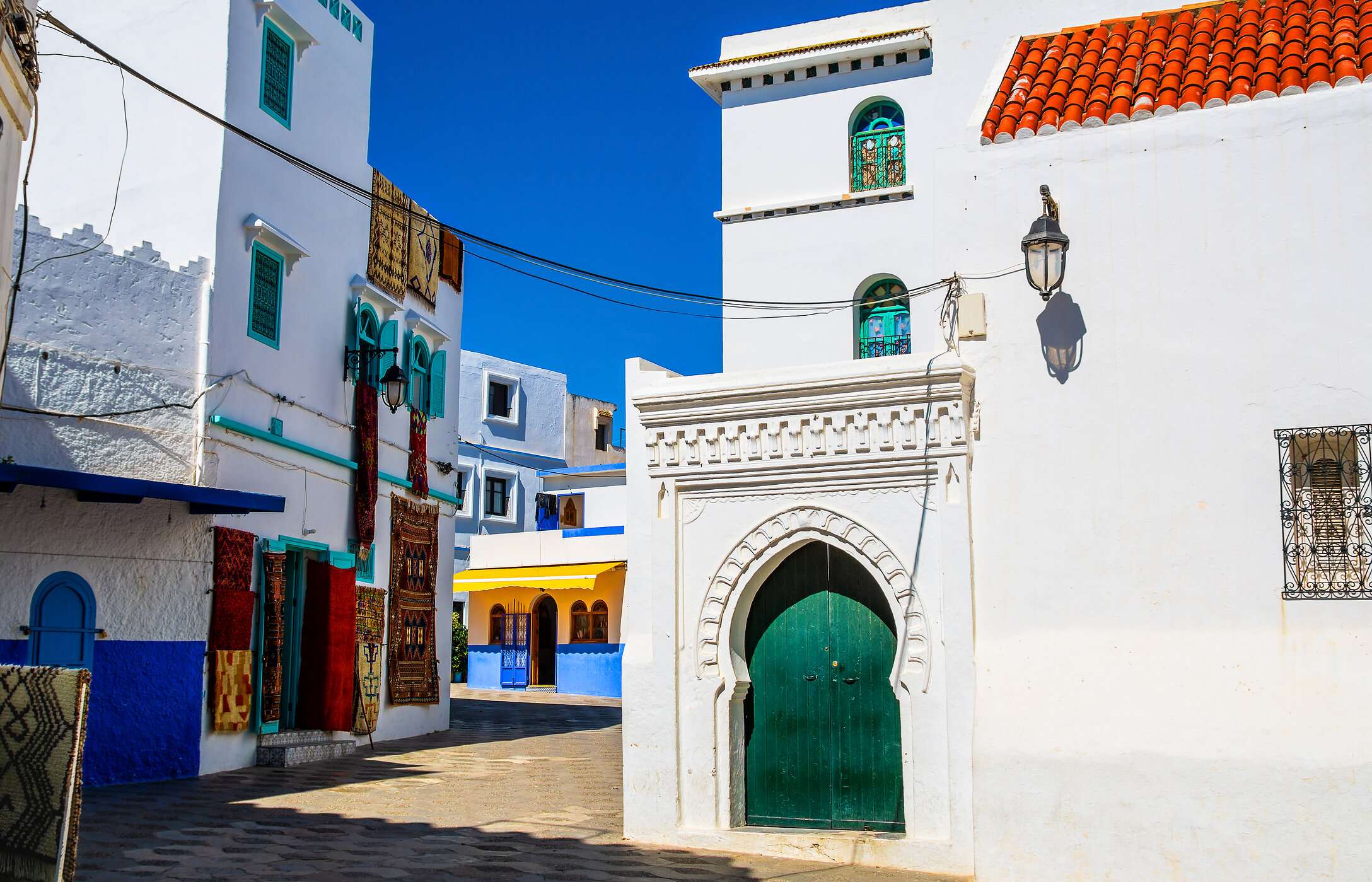 Pelas ruas estreitas de Tânger, é possível passear por recantos coloridos com tapeçaria pendurada