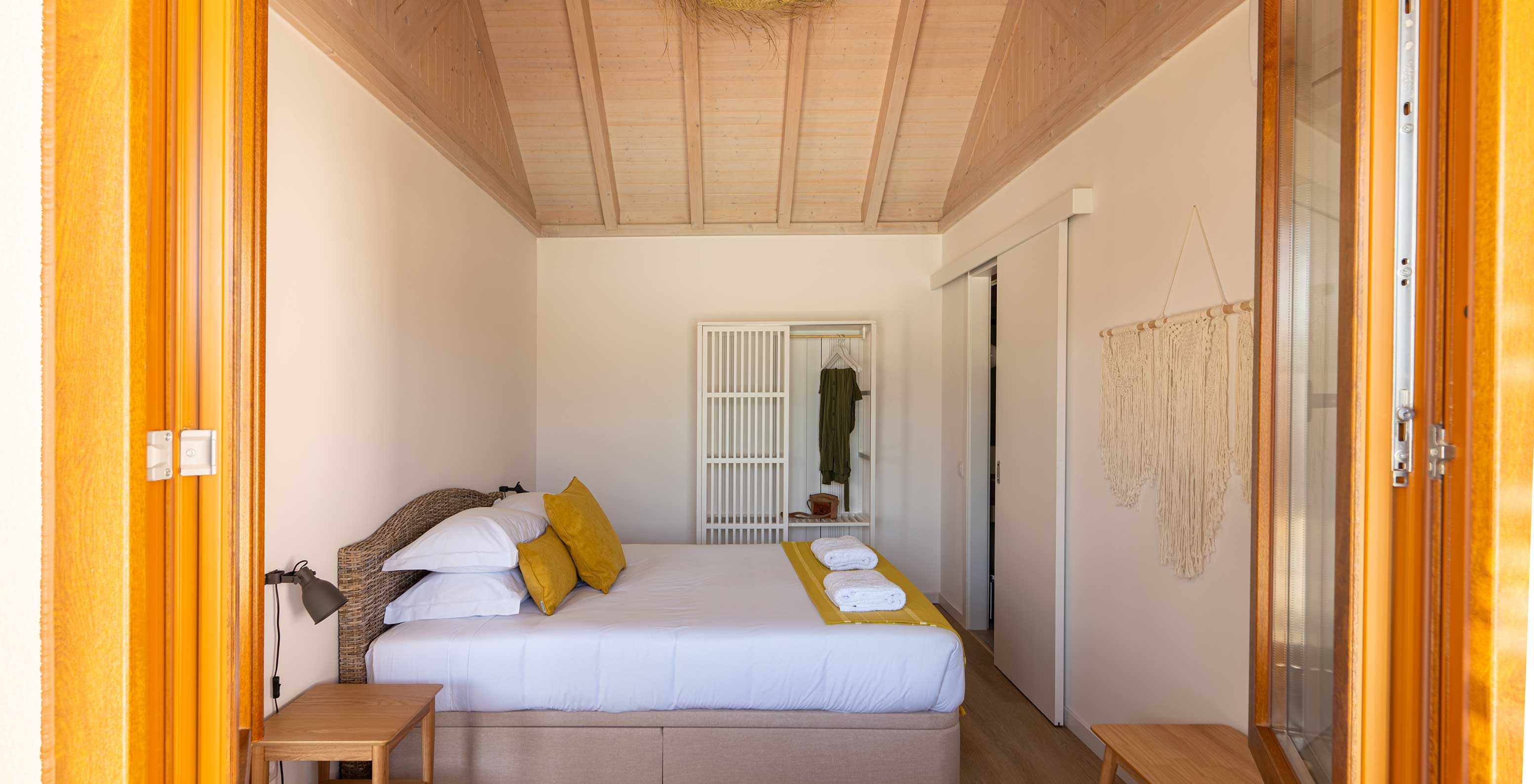 A Premium Villa do Pestana Comporta Village Residences tem um quarto com uma cama de casal, almofadas e um armário branco