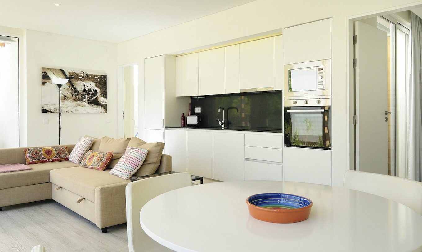 A Green Villa com Piscina Privada T3 do Pestana Tróia Eco Resort tem uma sala junta com a cozinha, sofá e mesa para jantar