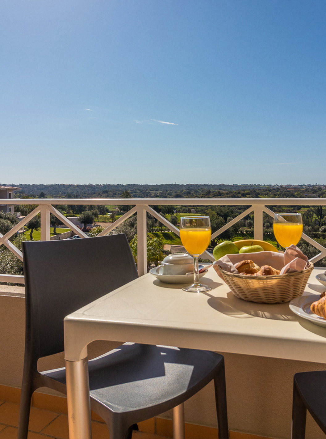 O Apartamento T2 do Pestana Gramacho Residences tem uma mesa ao ar livre em cenário ensolarado e acolhedor com vegetação.