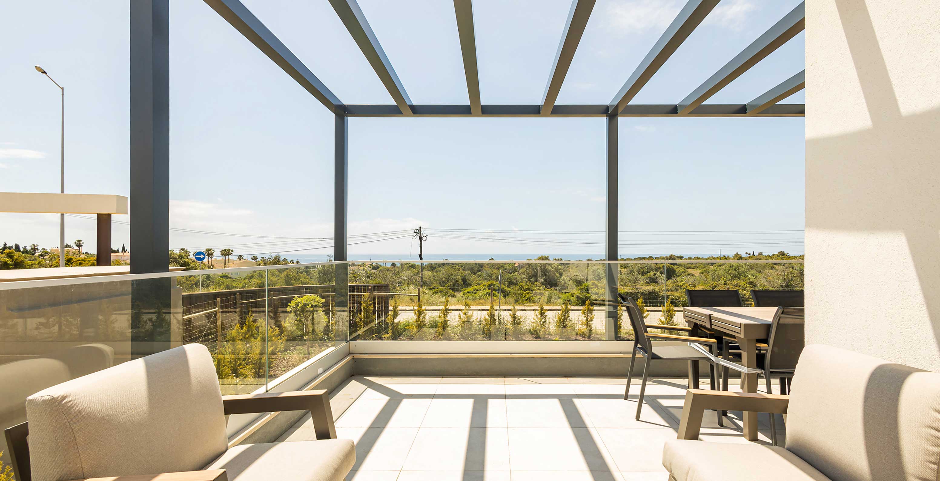 Apartamento do Pestana Valley Nature Village com um terraço com sofás e uma mesa de refeição