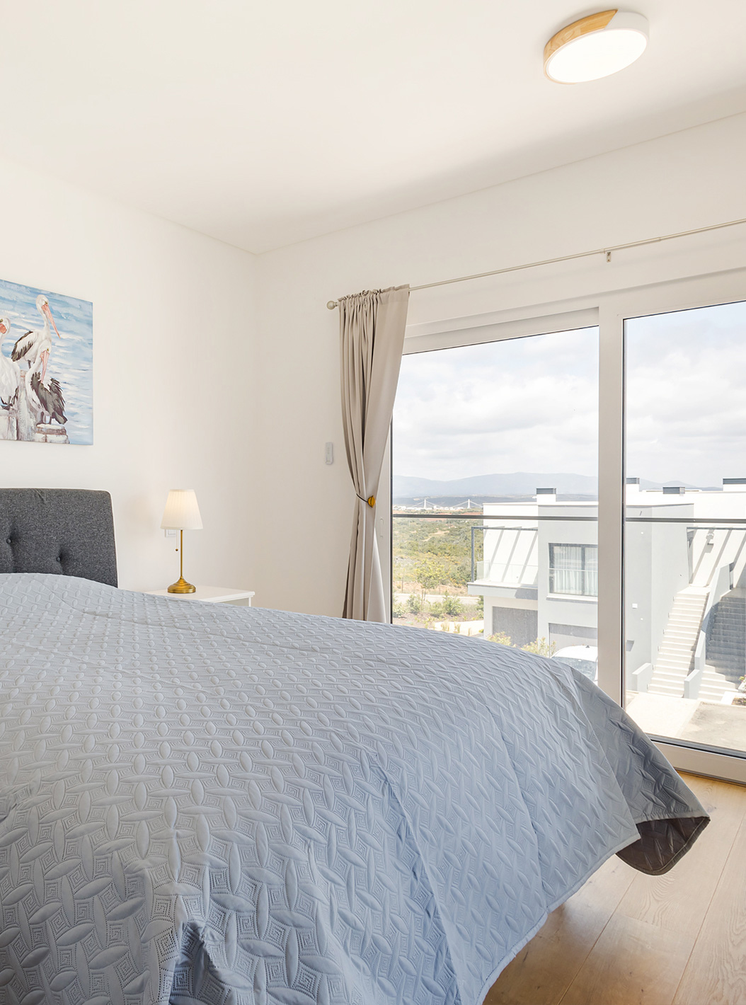 A First Floor 2 Bedroom Apartment do Pestana Valley Nature Village tem uma cama e cortinados com tons cinzentos