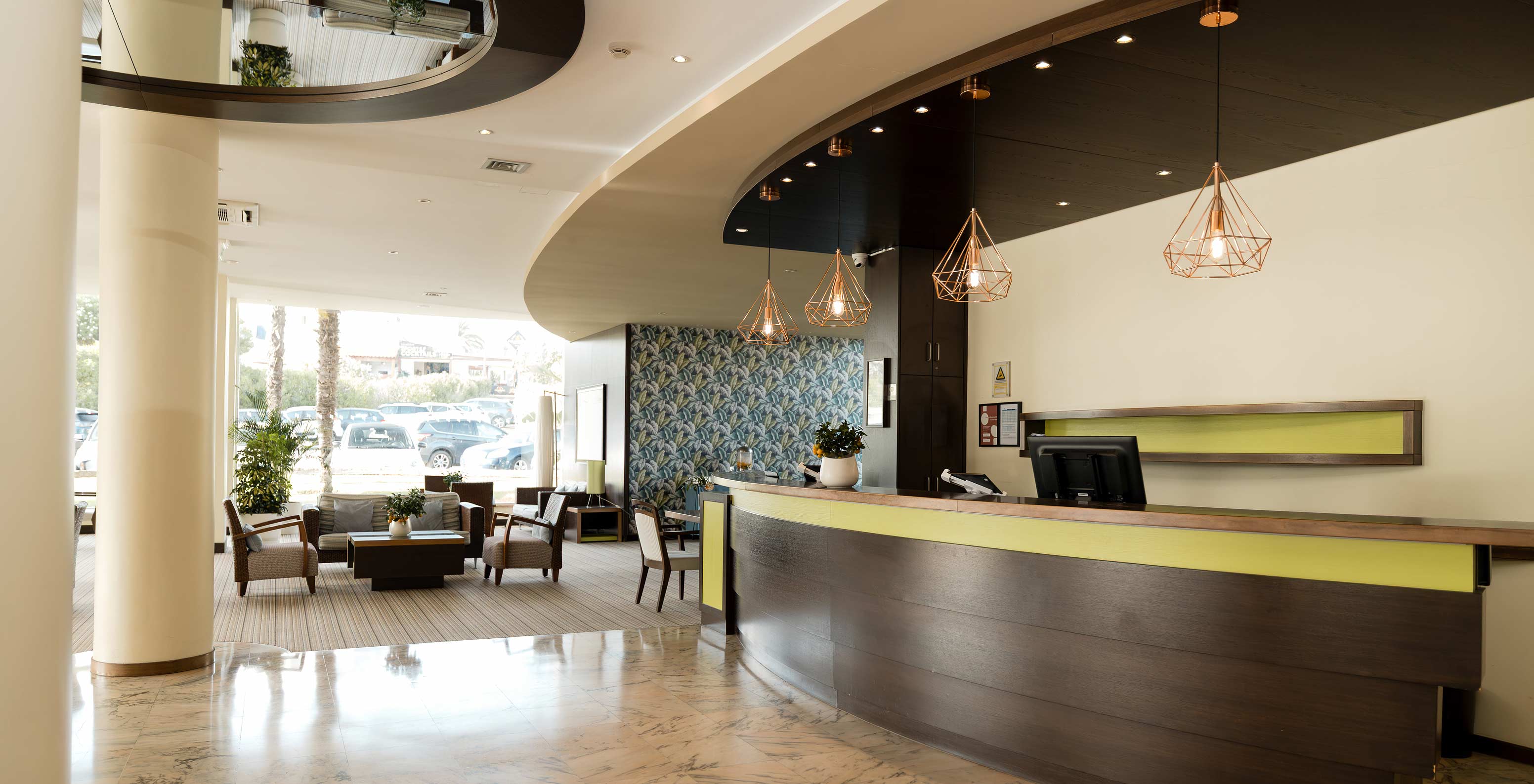 Receção do Hotel com Piscina em Armação de Pêra, com um lounge com luz natural e várias cadeiras e sofás confortáveis