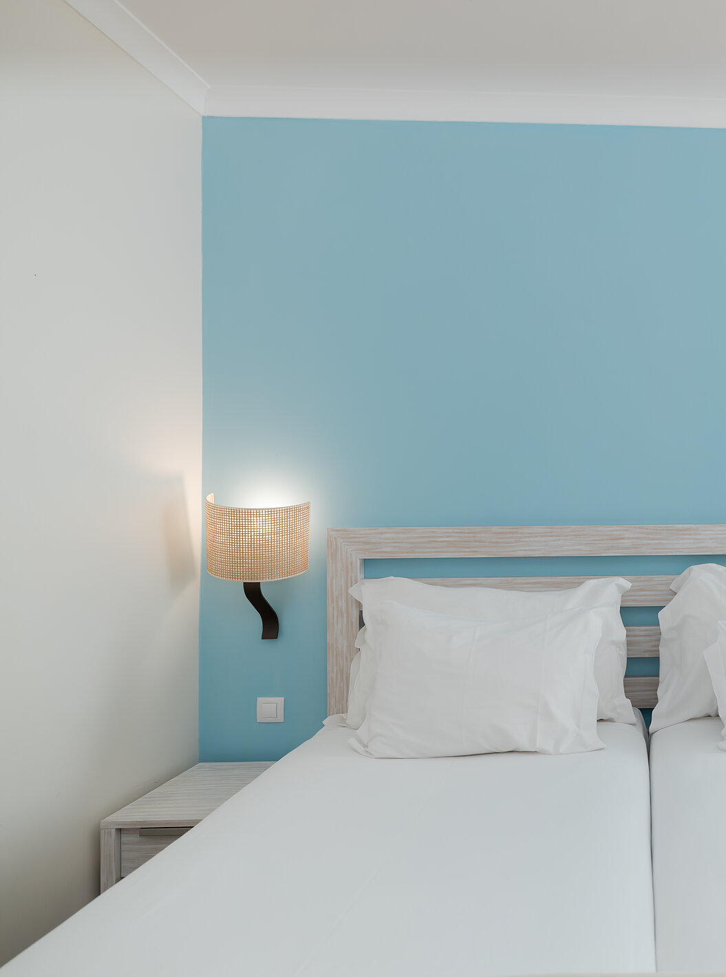 O Deluxe Vista Jardim do Pestana Viking tem duas camas individuais com duas mesas de cabeceira e papel de parede azul