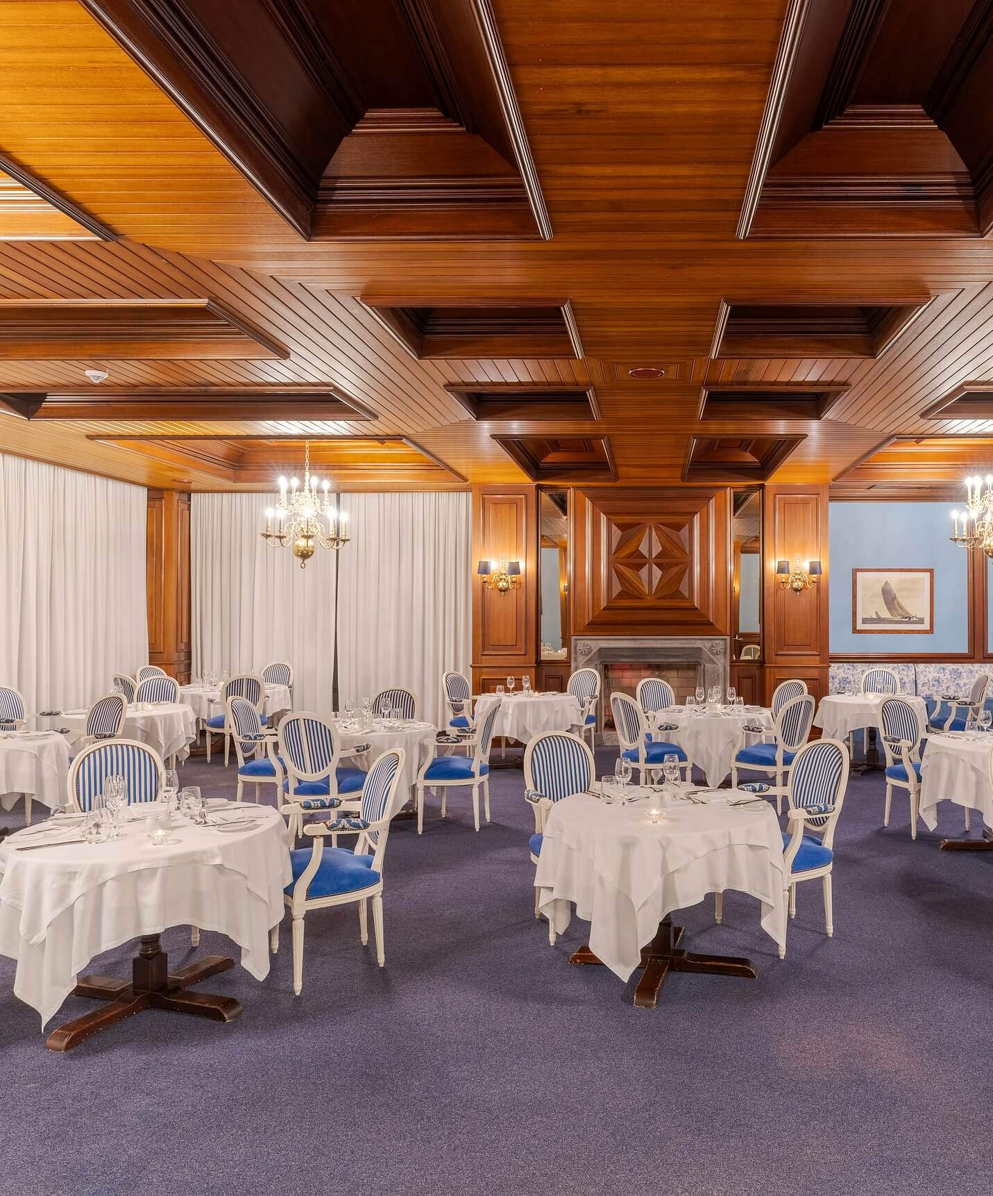 Sala de refeições clássica do Pestana Bahia Praia com teto em madeira e mesas com toalhas brancas