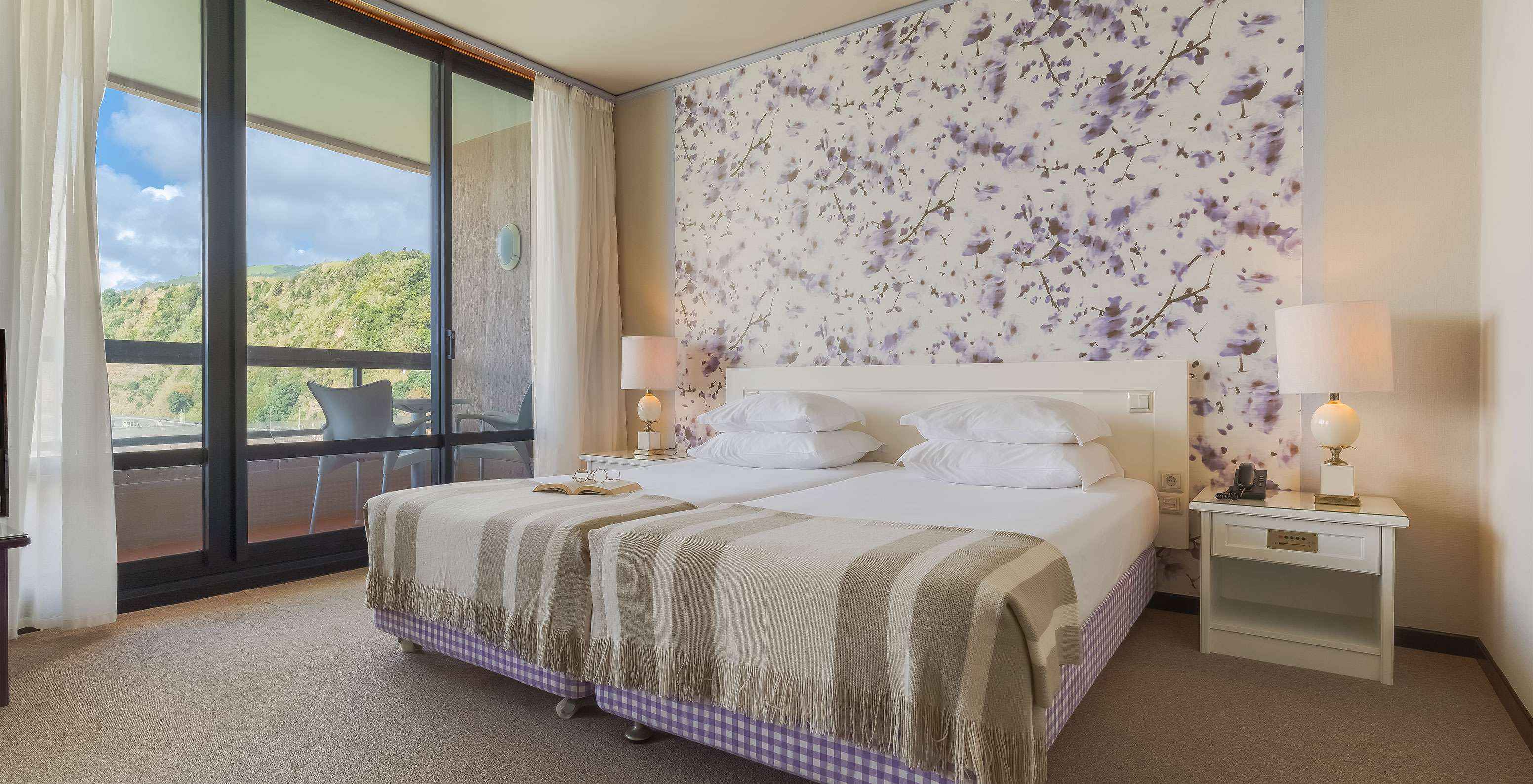 A Junior Suite Vista Mar do Pestana Bahia Praia tem um amplo espaço com duas camas individuais, com um sofá e uma cadeira