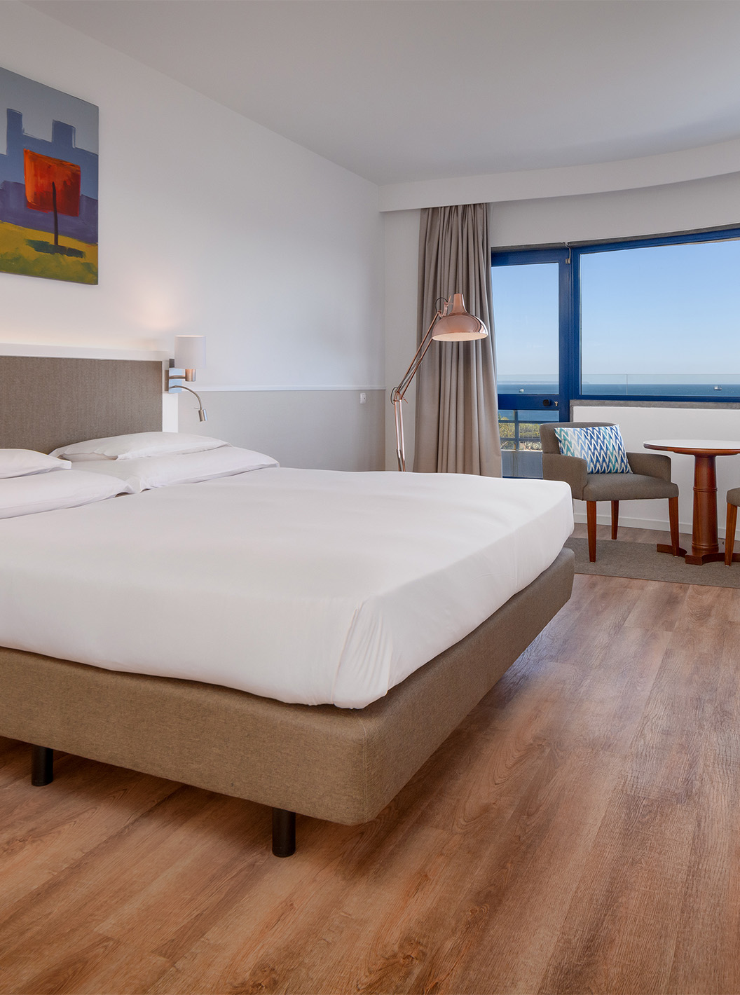 A Suite Deluxe Vista Mar do Pestana Cascais conta com cama de casal, televisão, e um quadro pintado na parede
