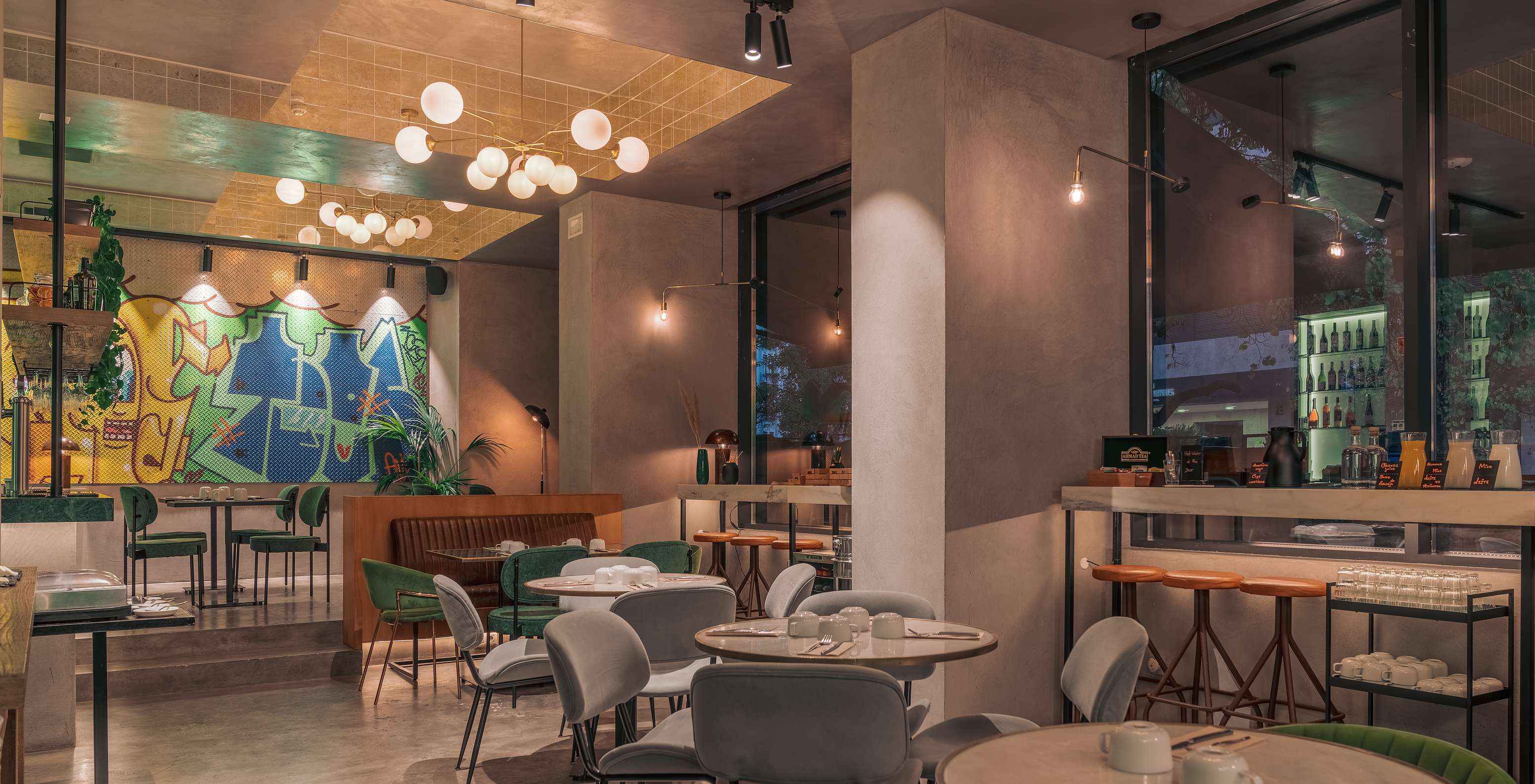 Restaurante do Pestana Lisboa Vintage com mesas e cadeiras coloridas, candeeiros de teto e balcões altos com cadeiras