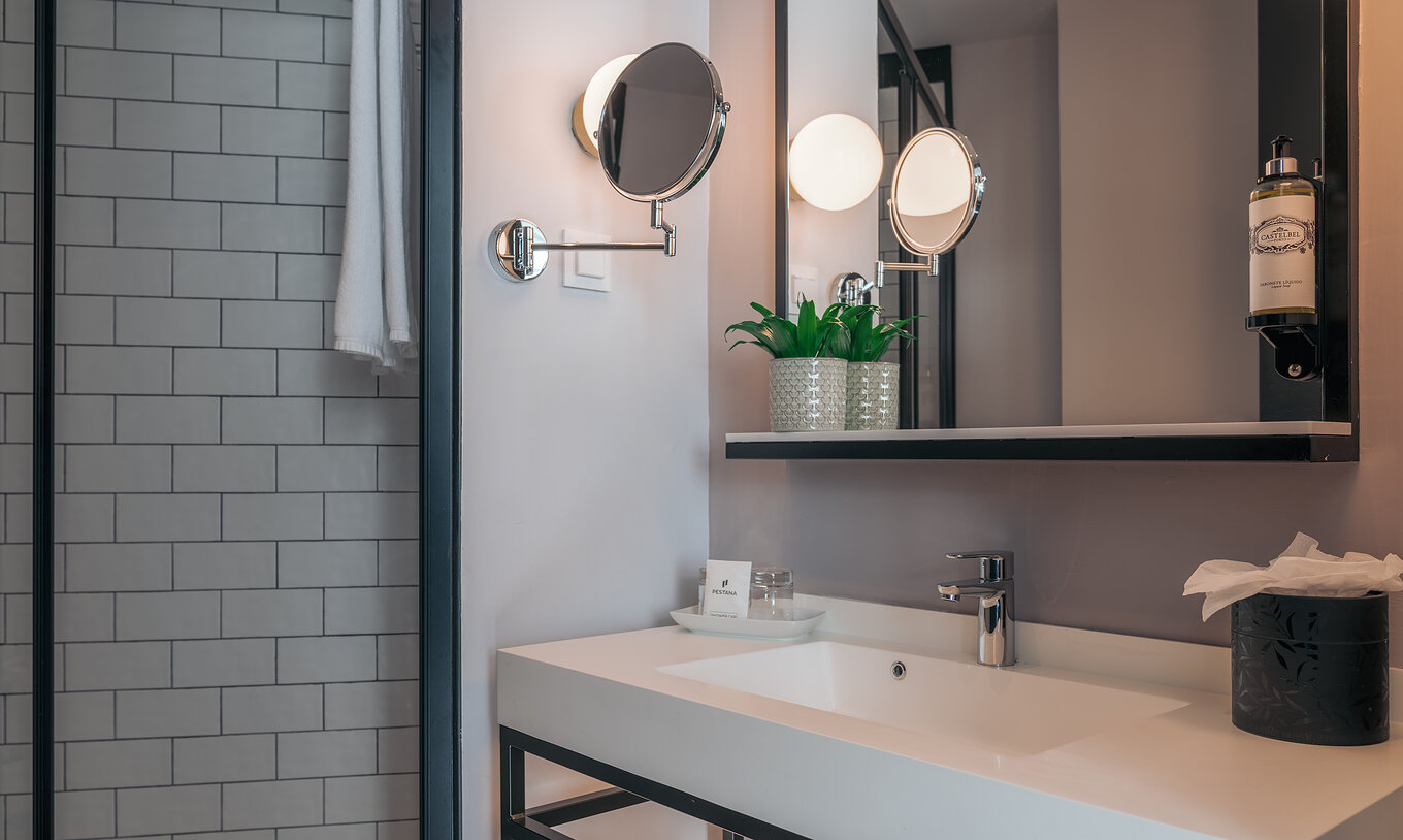 O Double Superior do Pestana Lisboa Vintage tem uma casa de banho com lavatório com dois espelhos e um duche lateral