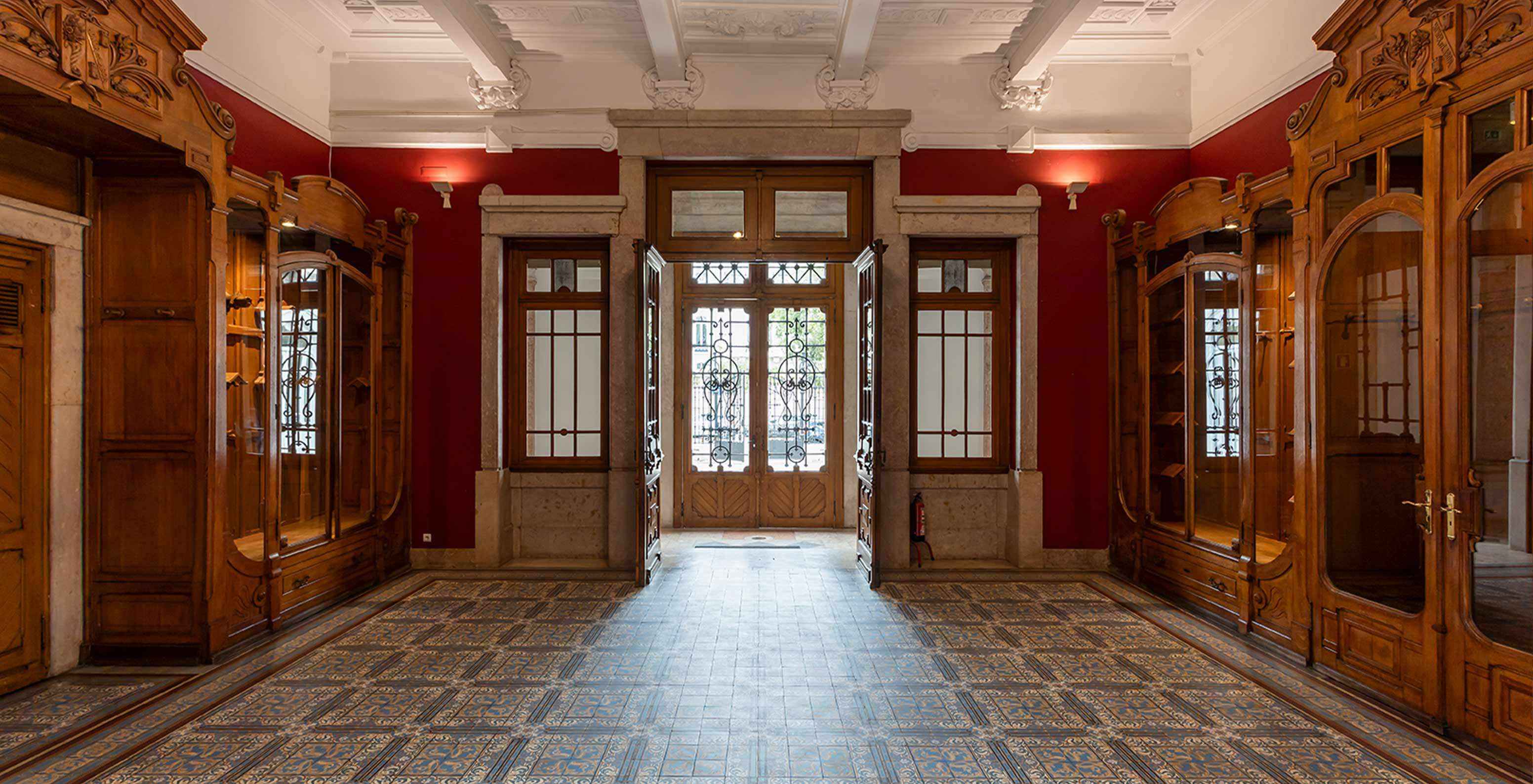 O Pestana Palace Lisboa tem uma sala de eventos com paredes vermelhas e mobília de madeira antiga