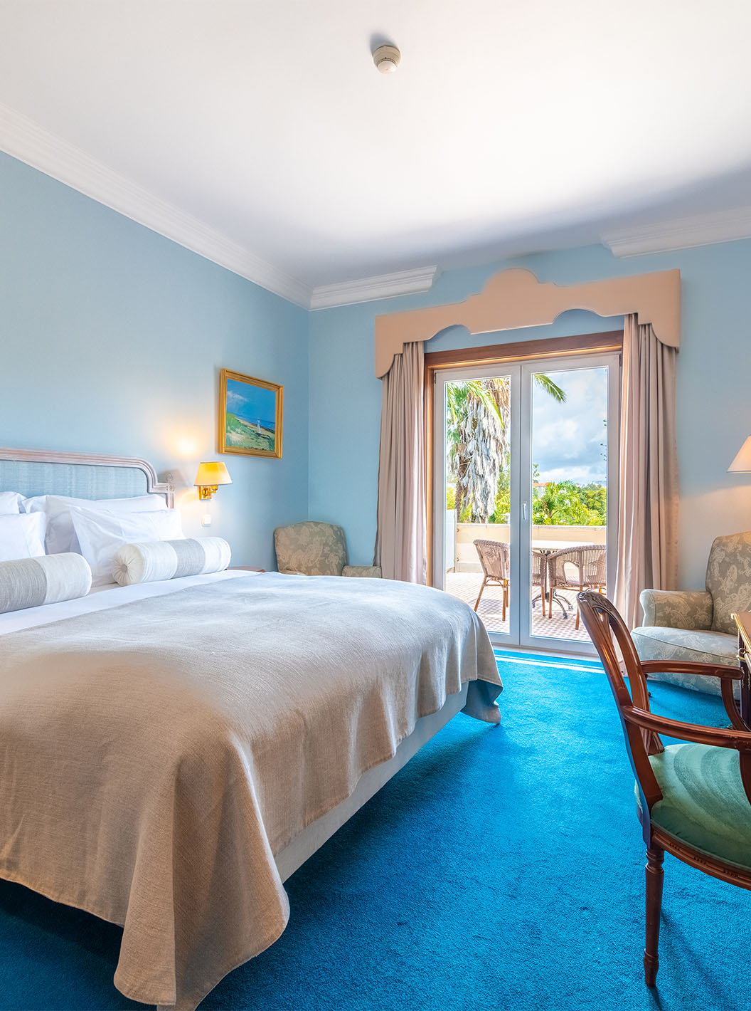 O Premium Balcony do Pestana Palace Lisboa tem uma cama de casal, paredes pintadas de azul claro e uma janela com cortinas