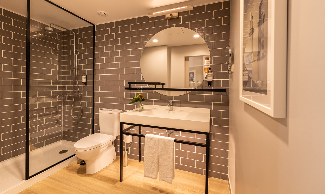 O Superior Familiar do Pestana Fisherman Village tem uma casa de banho com chuveiro, sanita e um espelho redondo