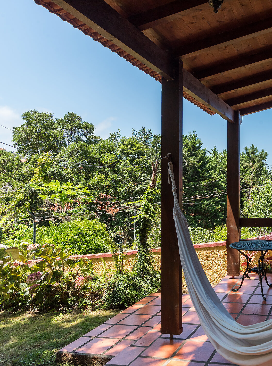 As Villas do Pestana Quinta do Arco tem uma cama de rede na varanda, com cadeiras e mesa de apoio e vista para o jardim
