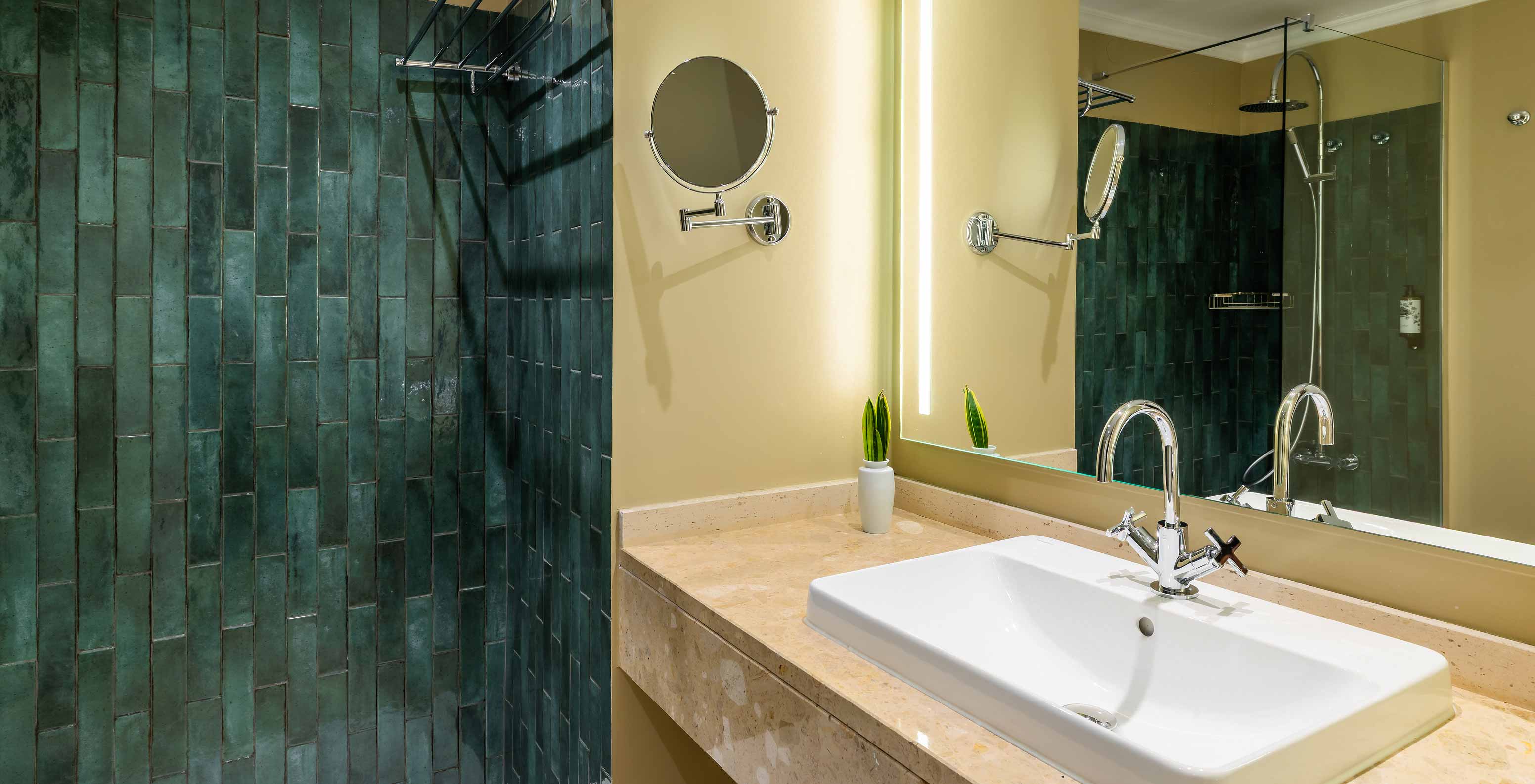 O Quarto Vista Mar Parcial com Varanda do Pestana Quinta Perestrello tem uma casa de banho com lavatório e azulejos