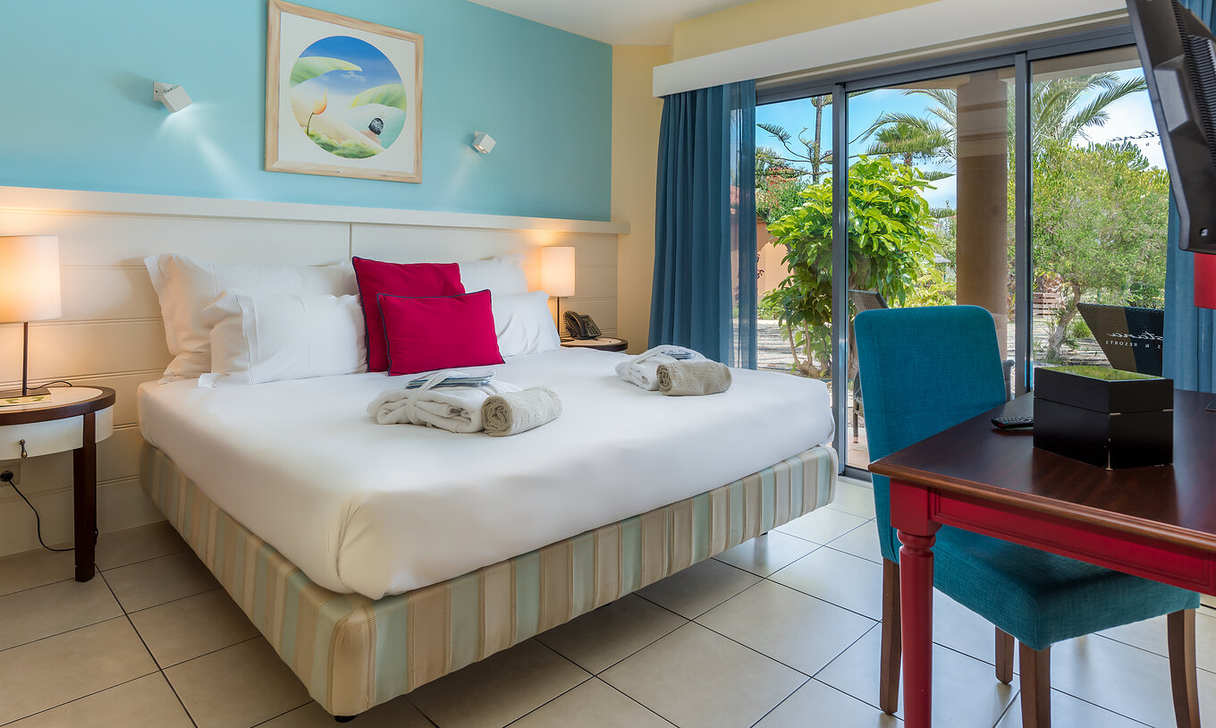 A Pool Villa do Pestana Porto Santo All Inclusive tem um quarto em tons de azul, com cama de casal e uma janela grande