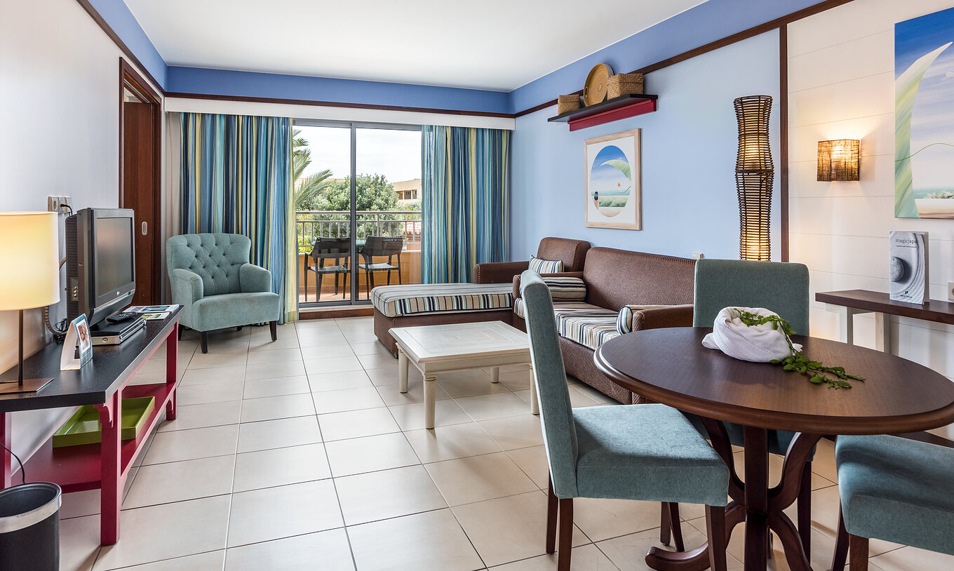 A Suite Apartamento T2 do Pestana Porto Santo All Inclusive tem uma sala com dois sofás, televisão e acesso à varanda