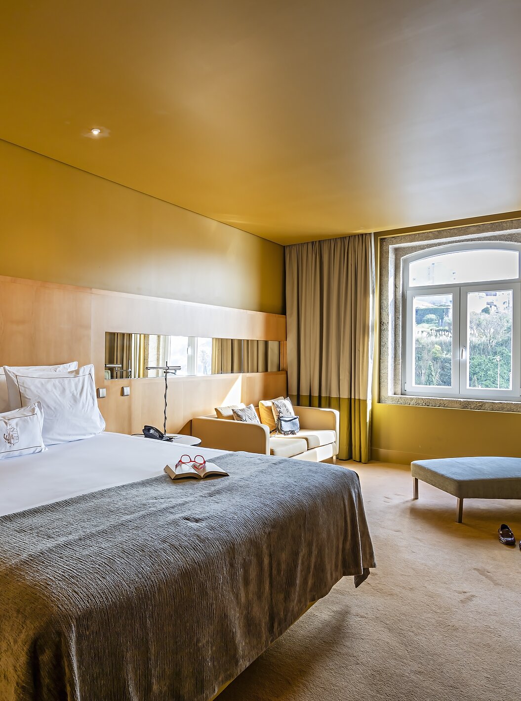 O Superior do Pestana Palácio do Freixo tem uma cama de casal com colcha cinzenta e uma janela com vista