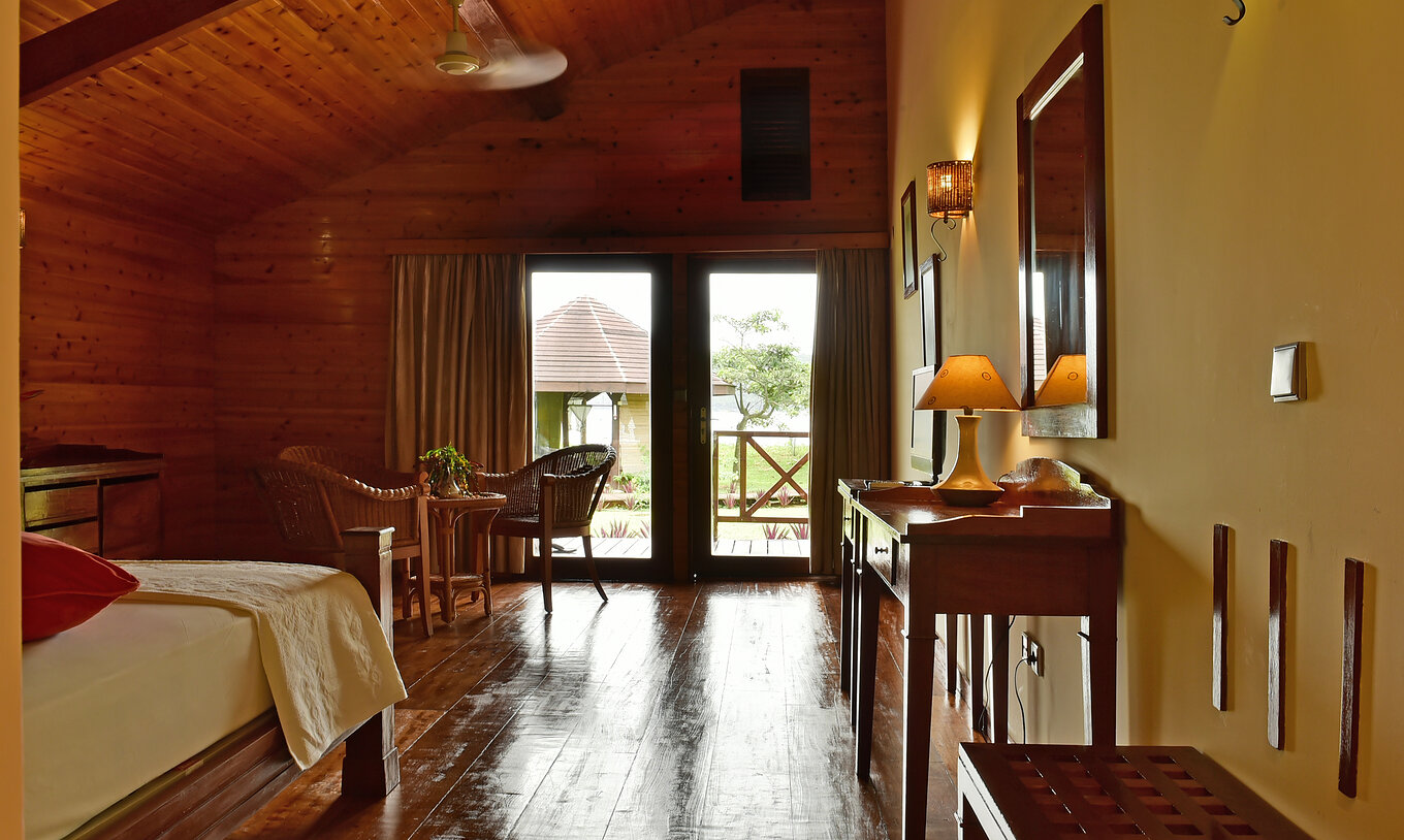 O Duplo Superior do Pestana Equador Ilheu das Rolas tem uma cómoda em madeira, um espelho, e janela com vista para o jardim