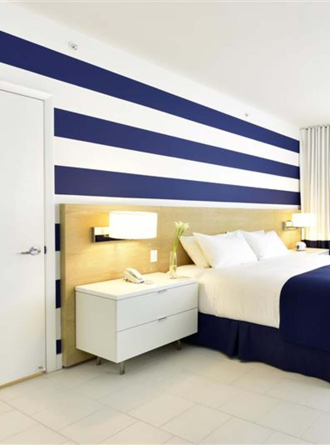 O Superior King do Pestana Miami South Beach é um quarto moderno com cama de casal, decoração azul e branca e luz natural