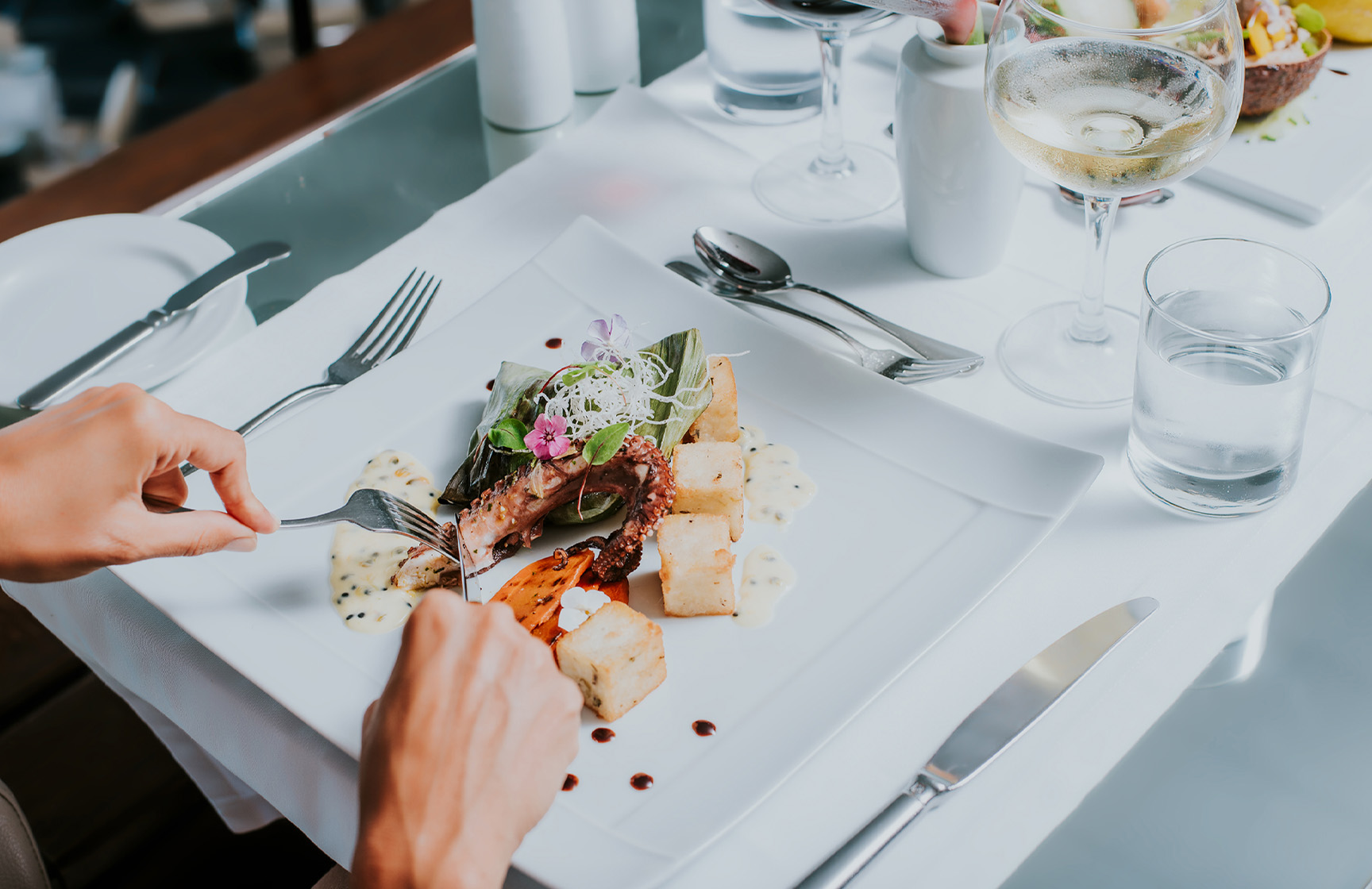 Prato branco com polvo e milho frito, numa estadia com refeição num hotel da marca Pestana Hotels and Resorts