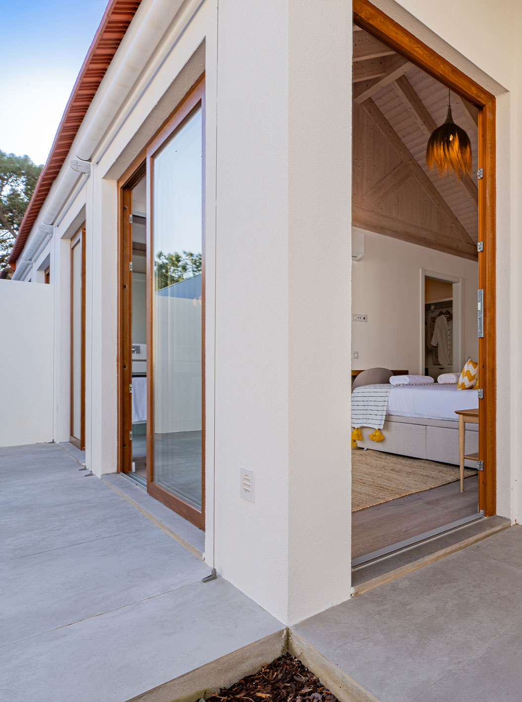 Villa Standard Verde do Pestana Comporta com vista do exterior, mostrando porta aberta para quarto iluminado