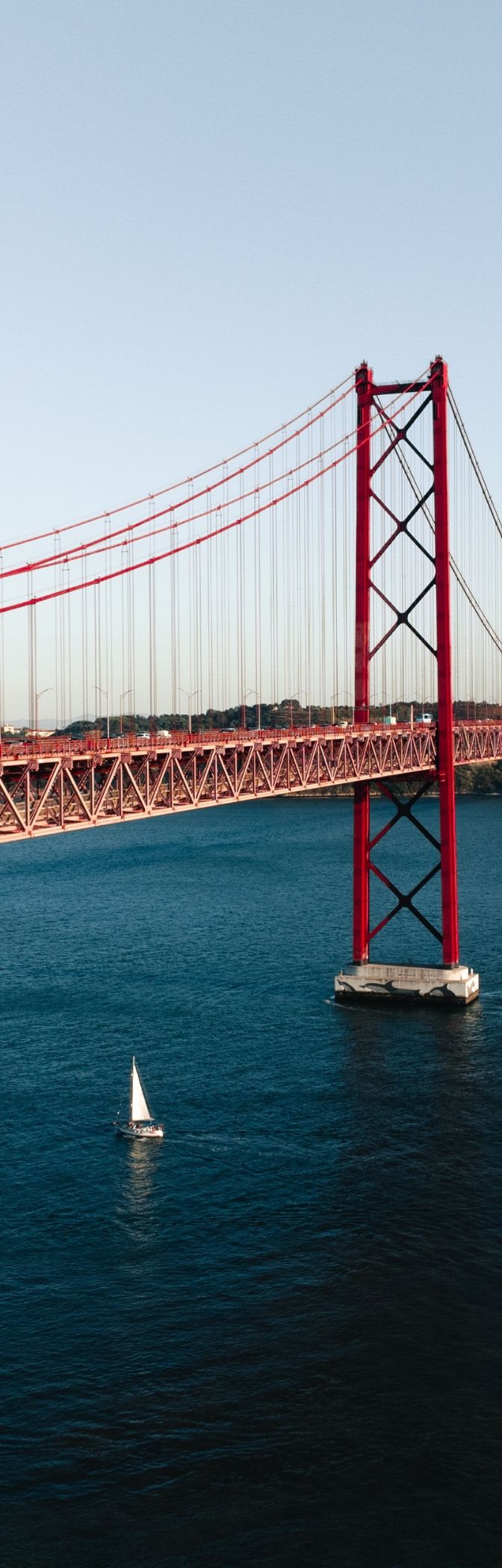 Vista panorâmica da cidade de Lisboa, com o Rio Tejo com vários barcos e a ponte 25 de Abril