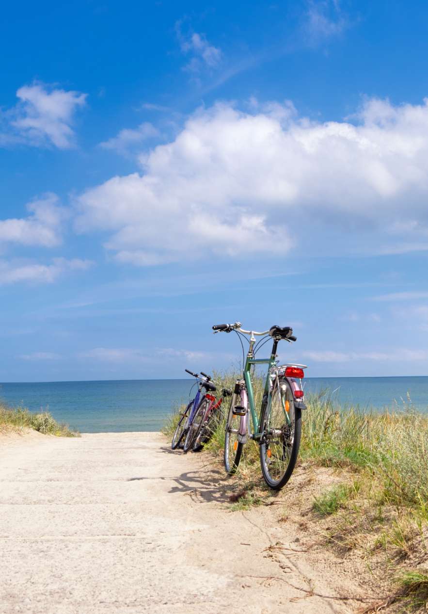Twee fietsen geparkeerd langs de weg, naast het strand, na een lange fietstocht