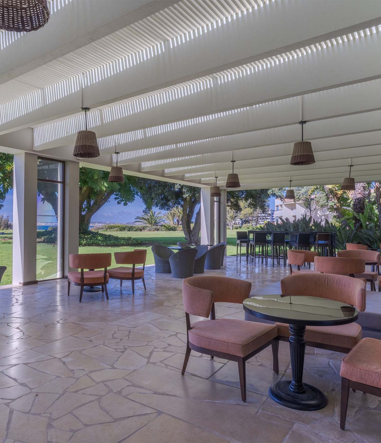 De bar D Henrique, van het 5-sterrenhotel in de Algarve, heeft tafels op het terras met uitzicht op de tuin en zee