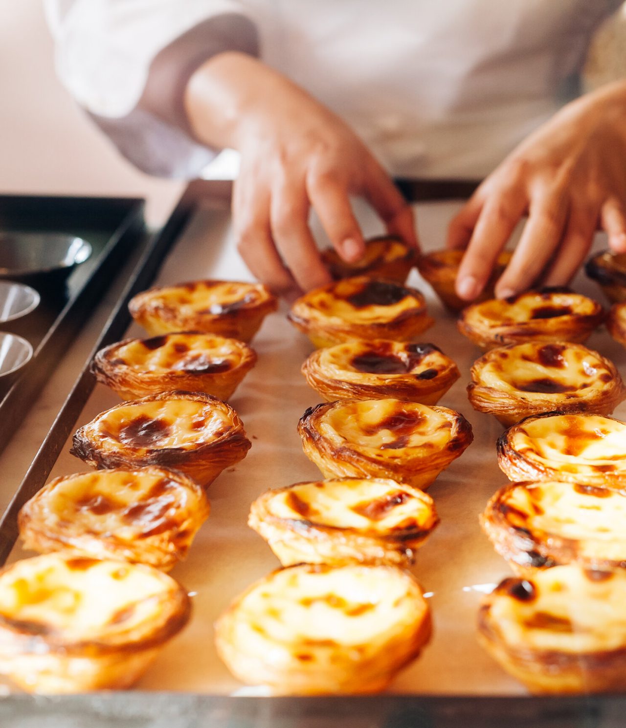Chef die pastéis de nata uit de vorm haalt, een typische Portugese lekkernij uit Lissabon