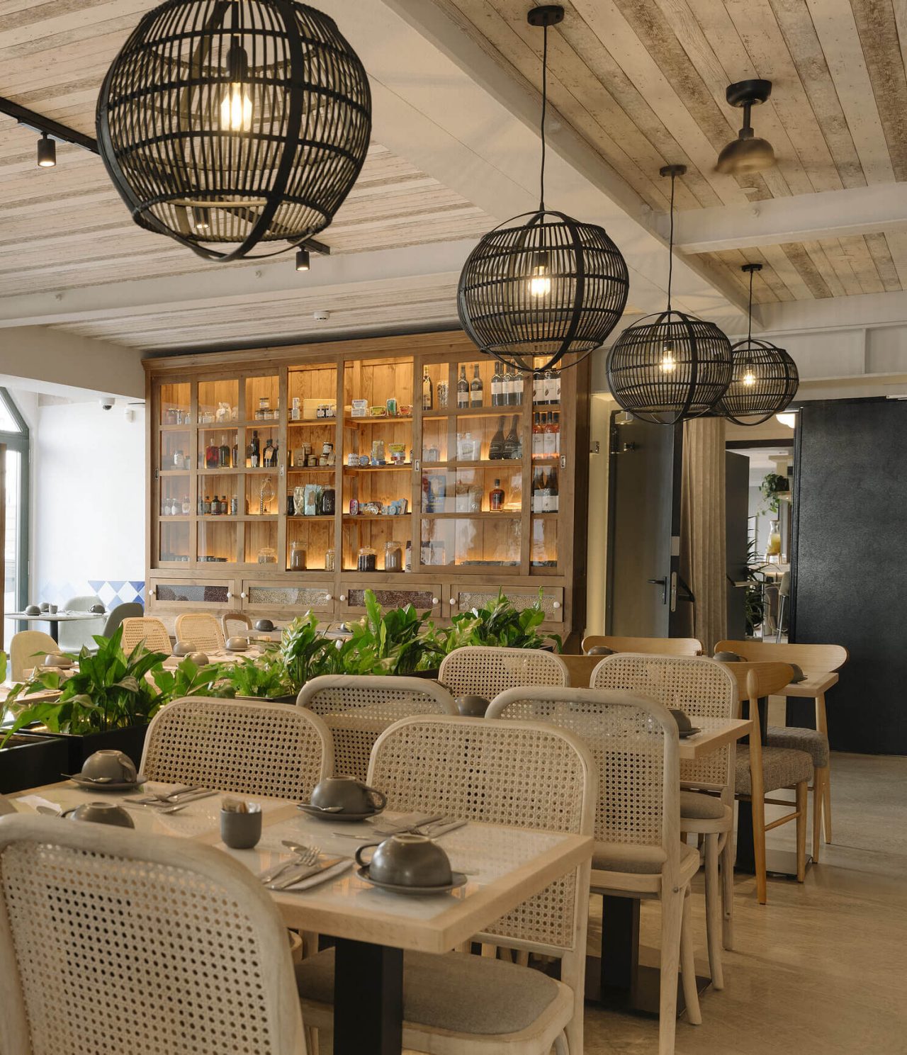 Restaurant Olive van het hotel in het centrum van Lissabon heeft meerdere tafels, planten en moderne decoratie