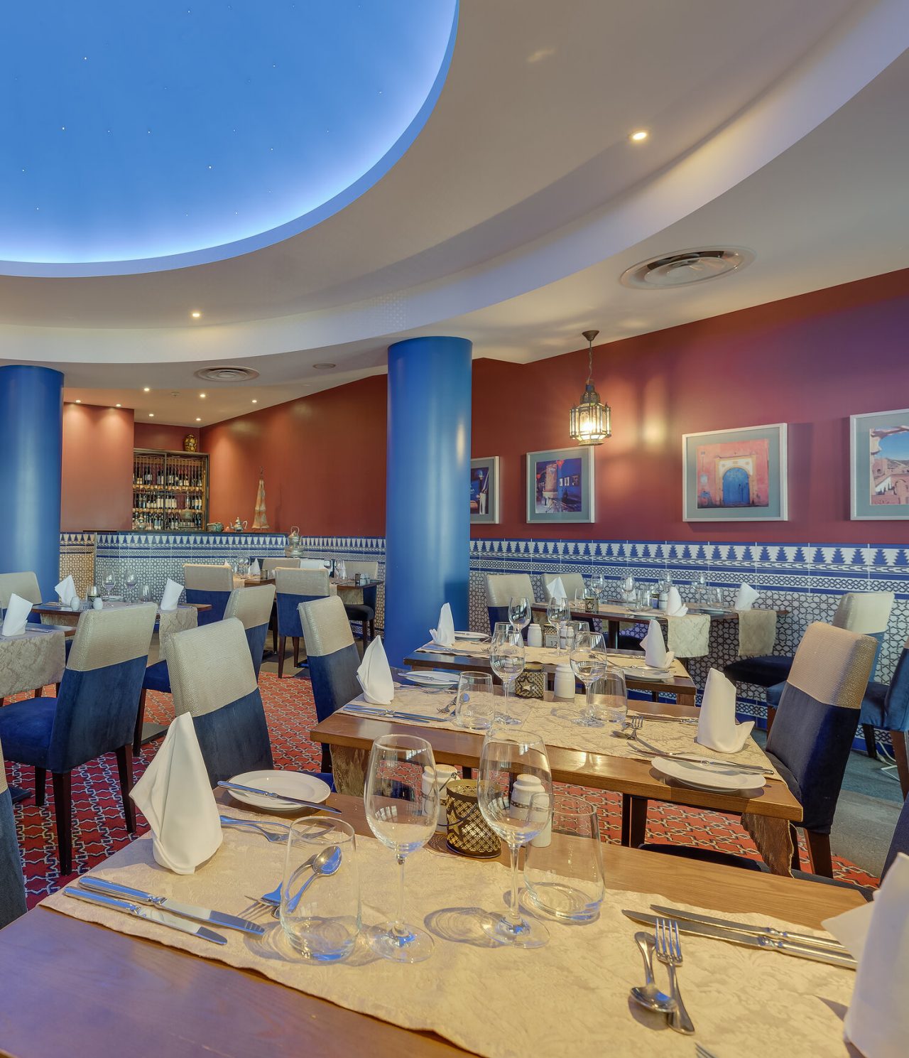 Het restaurant Au Tagine, van het 5-sterrenhotel in Funchal, op Madeira, heeft een ruime zaal met schilderijen en tafels