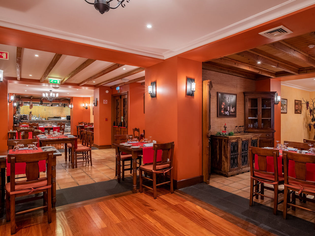 Het restaurant Adega Madeirense, van het 4-sterrenhotel in het centrum van Funchal, heeft antieke decoratie en oranje muren