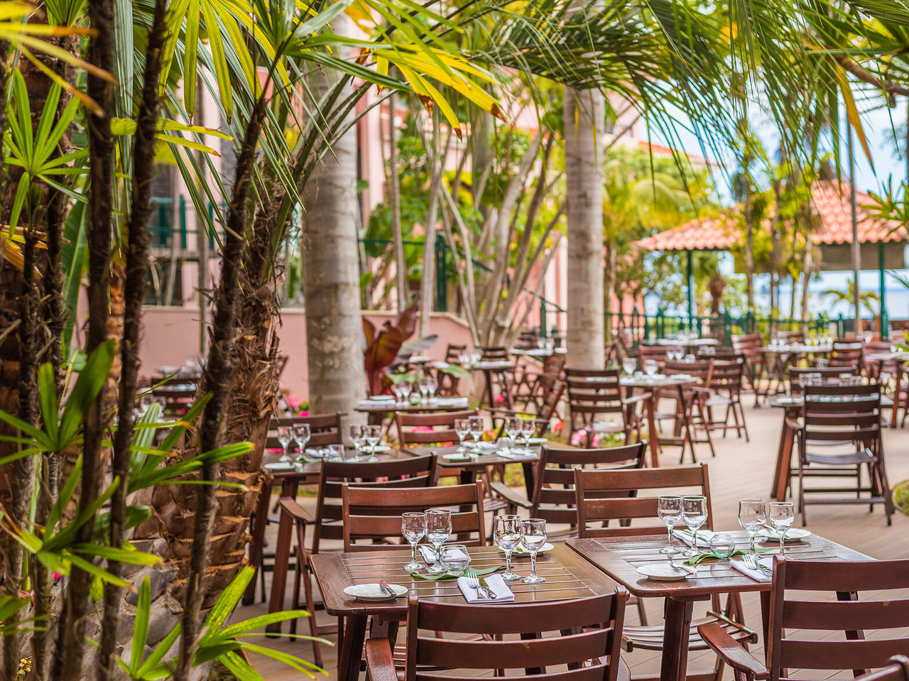 Het restaurant Botanic Terrace, van het 5-sterrenhotel in Funchal, heeft een buitenrestaurant met tafels en stoelen