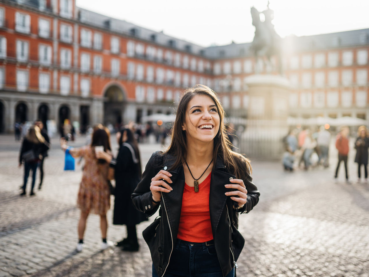 Gelukkig meisje met rugzak wandelt door de Plaza Mayor, in het historische centrum van Madrid