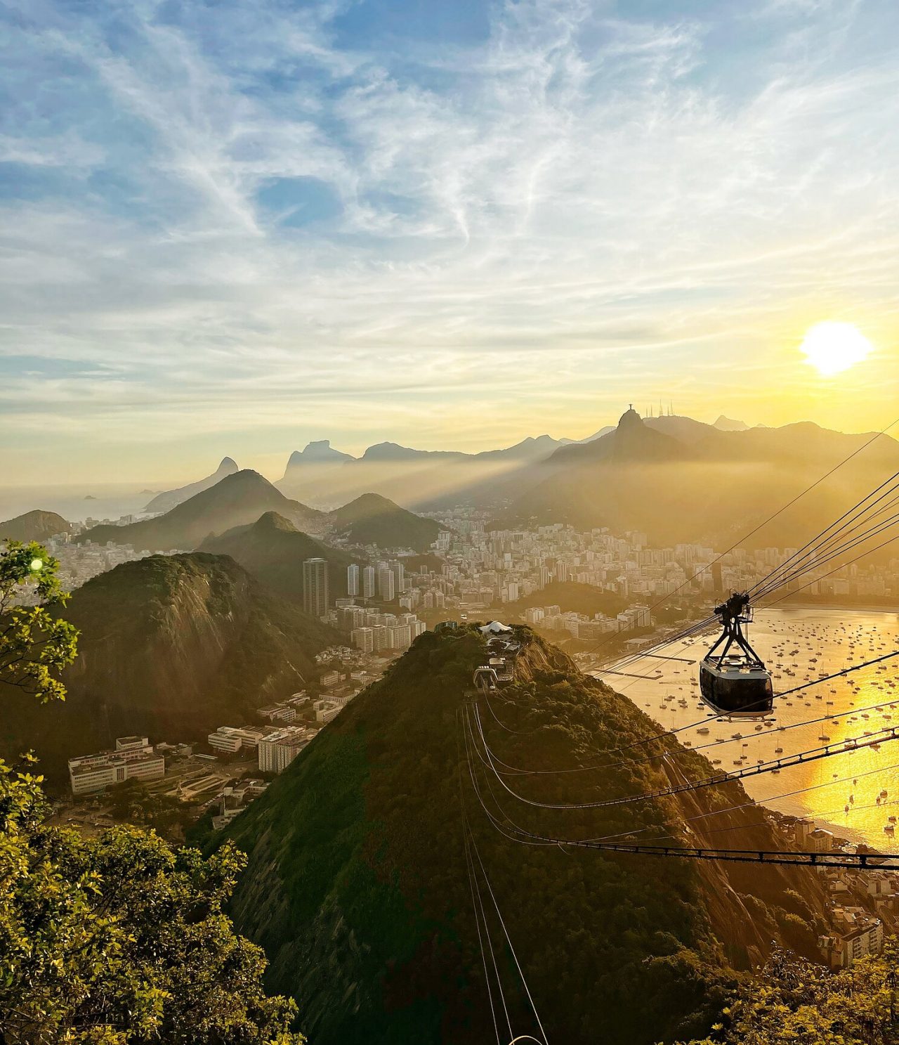 Luchtzicht op Rio de Janeiro, met een kabelbaan richting een heuvel, met de stad en het strand op de achtergrond