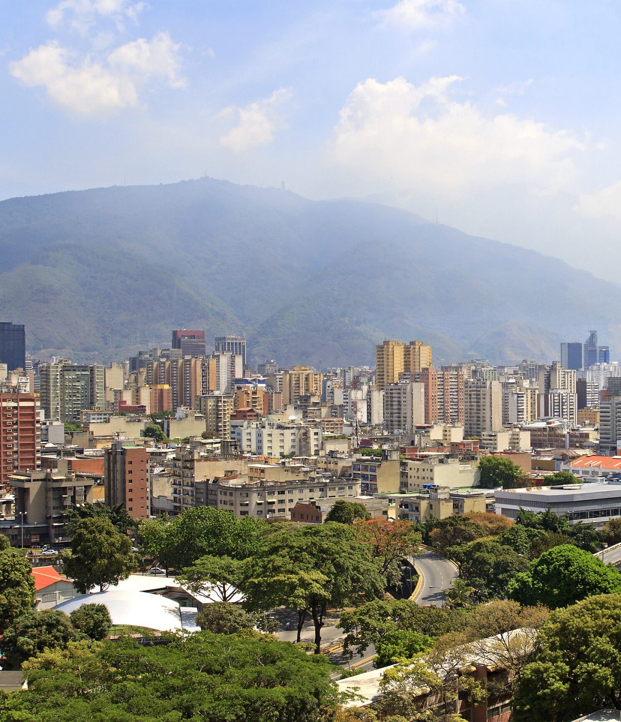 Panoramisch luchtzicht op Caracas, met verschillende hoge gebouwen, enkele moderne constructies en vegetatie