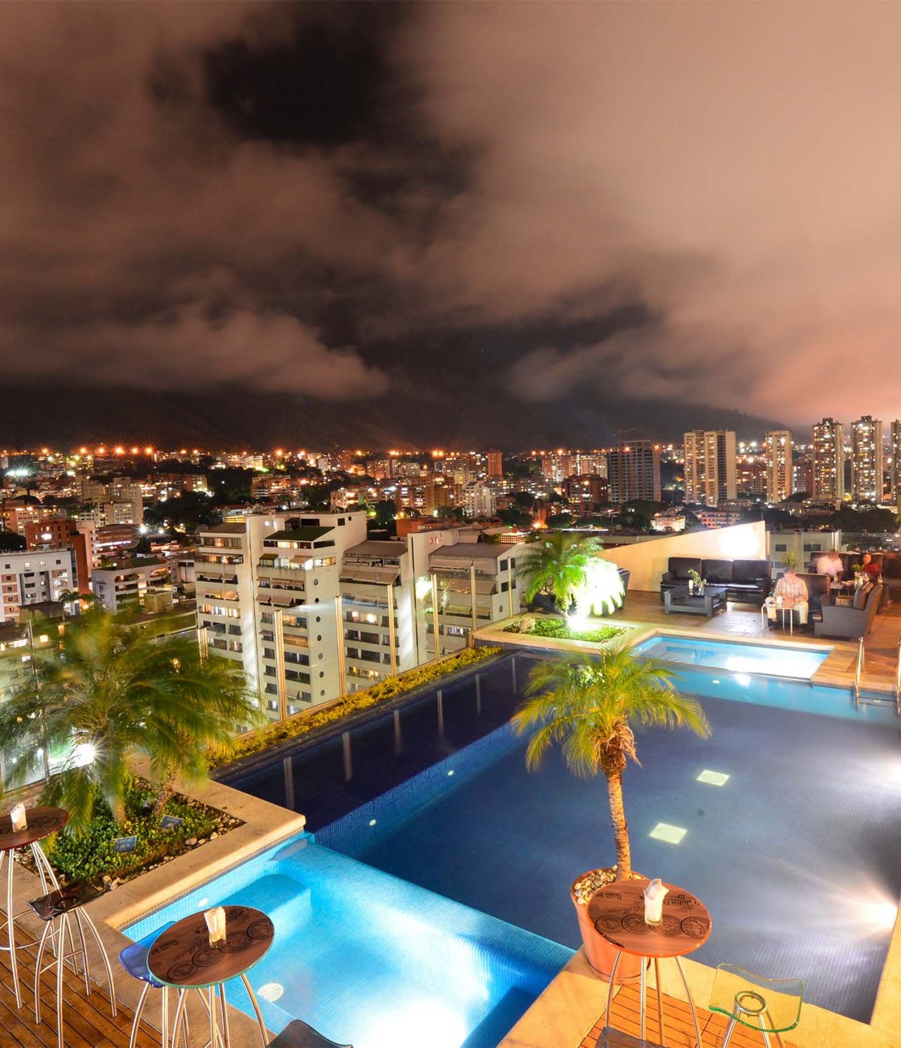 De bar Lounge Vip 19, van het Hotel in Caracas, heeft een zwembad, palmbomen en panoramisch uitzicht op de stad